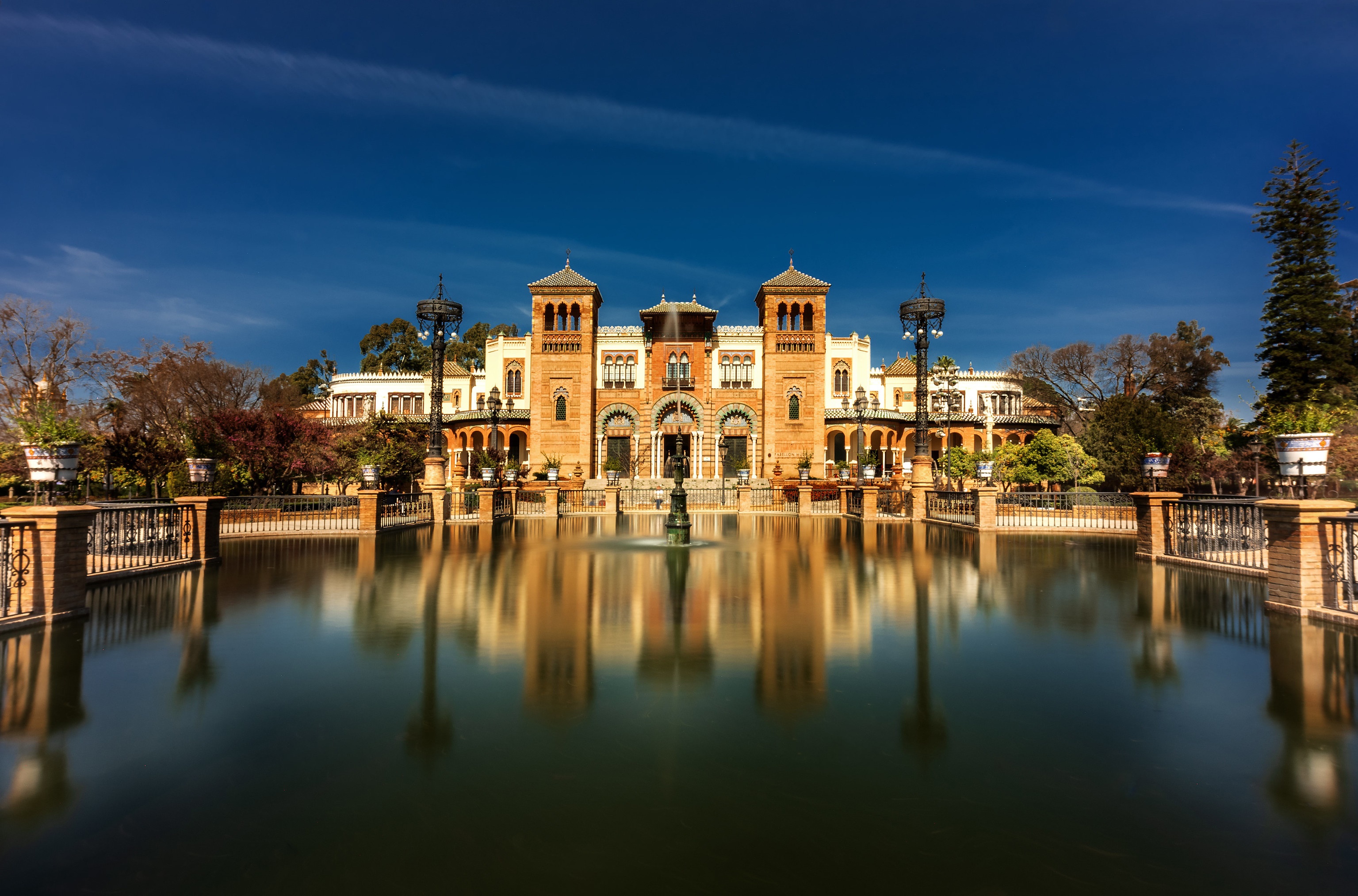 Palacio Mudejar in Seville, Spain with reflection in pond HD Wallpaper