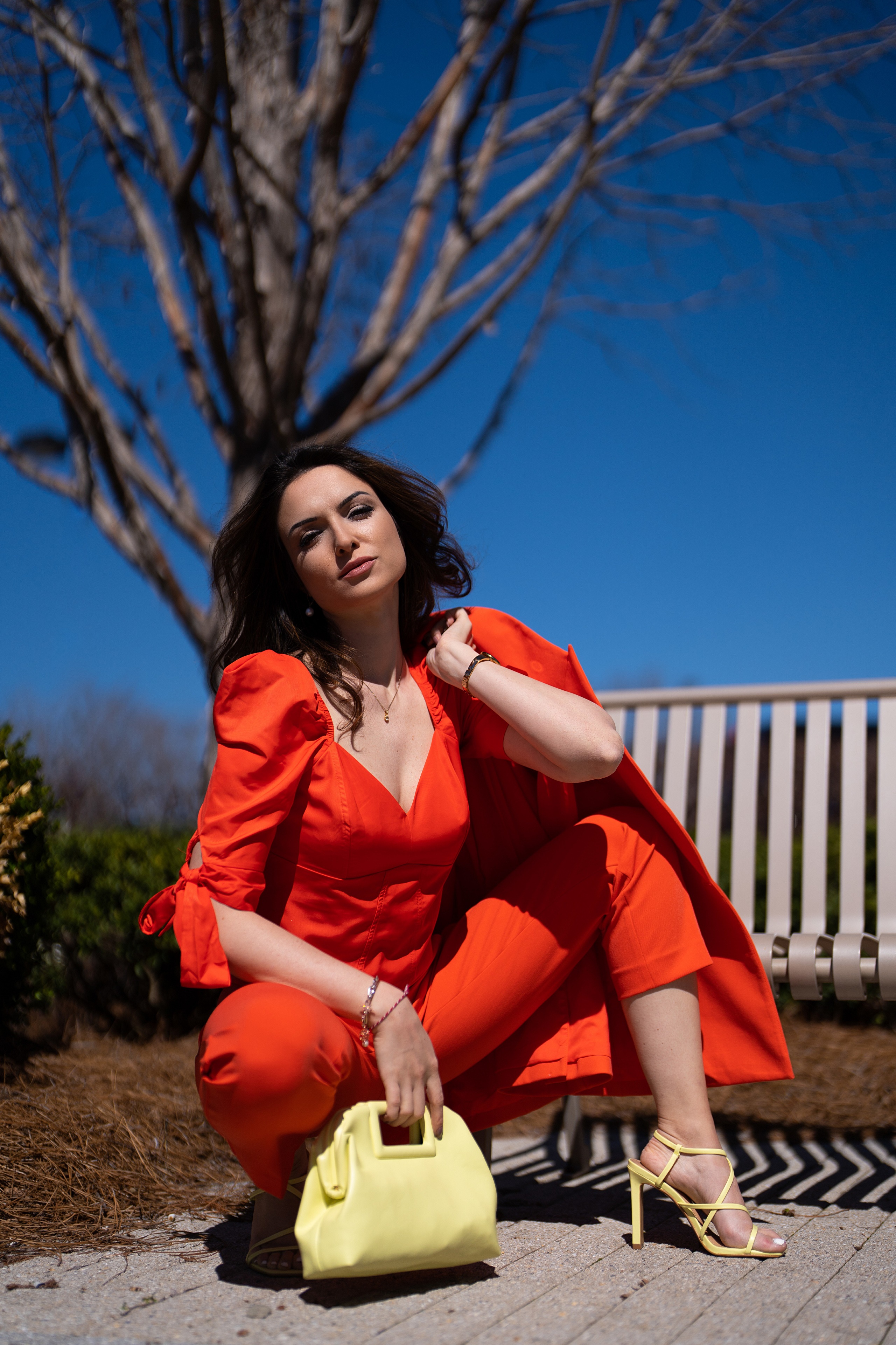 Woman in orange suit posing with handbag HD Phone Wallpaper