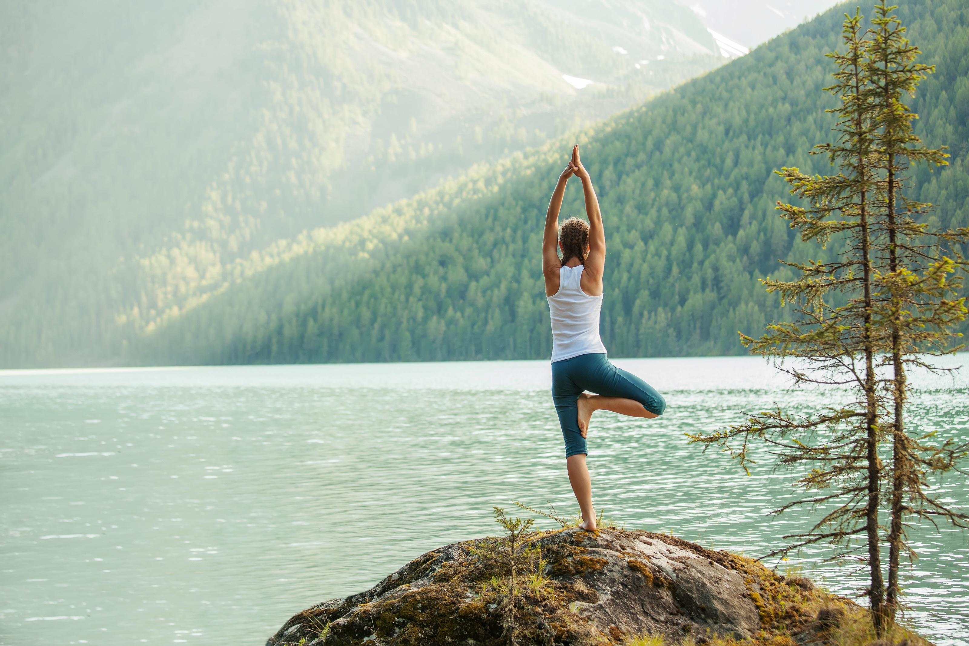 Woman doing yoga tree pose by a lake HD Wallpaper