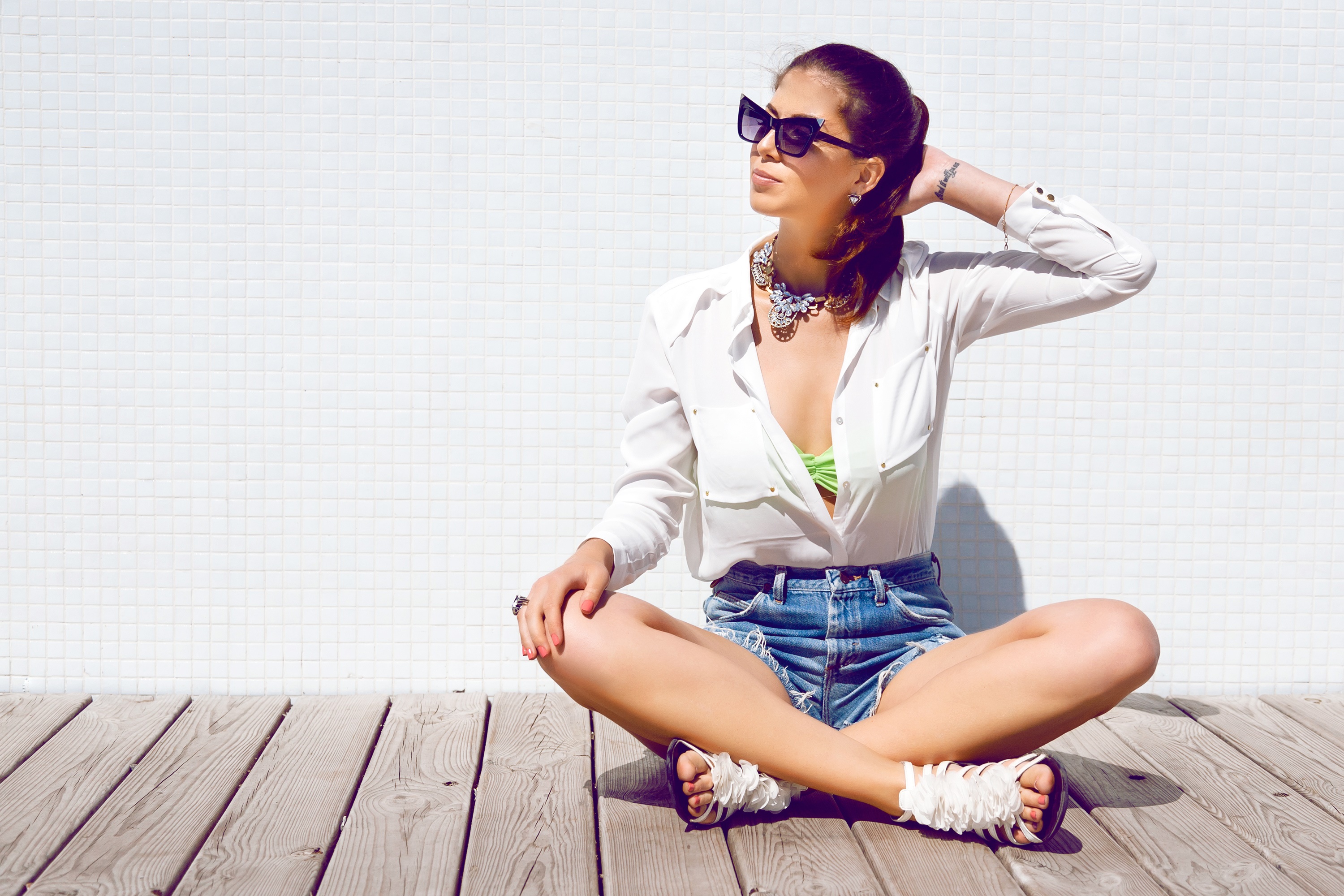 Brunette girl in sunglasses and white shirt sitting on wooden floor HD Wallpaper