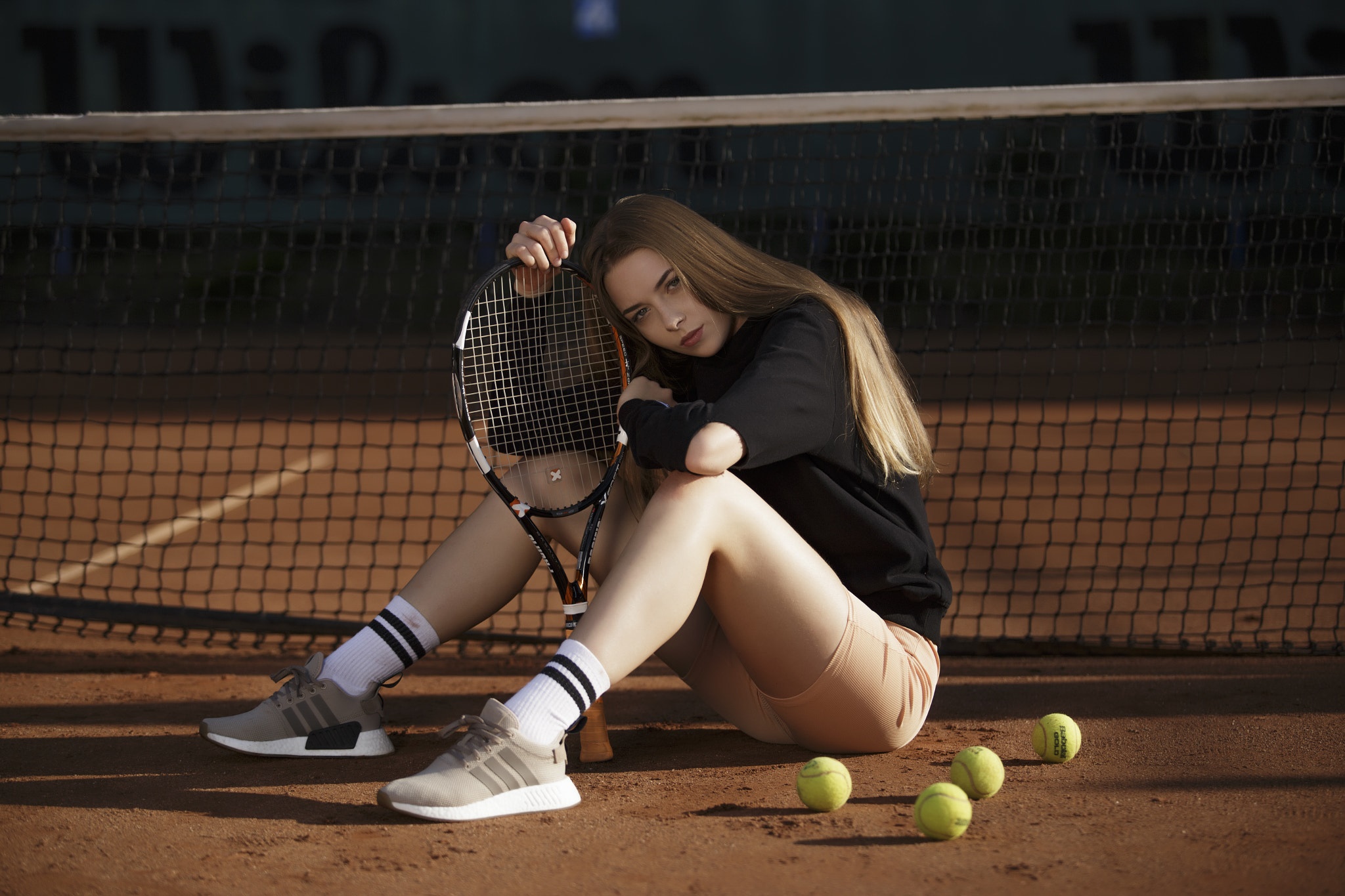 Young woman with tennis racket sitting on court HD Wallpaper
