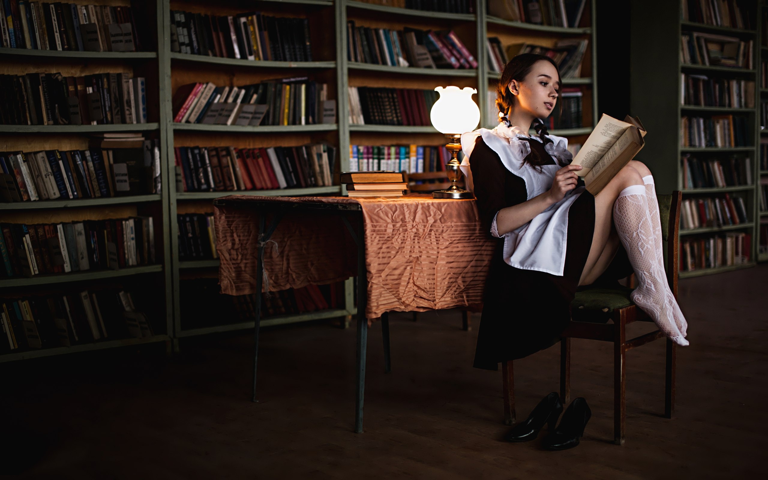 Schoolgirl reading a book in a library HD Wallpaper