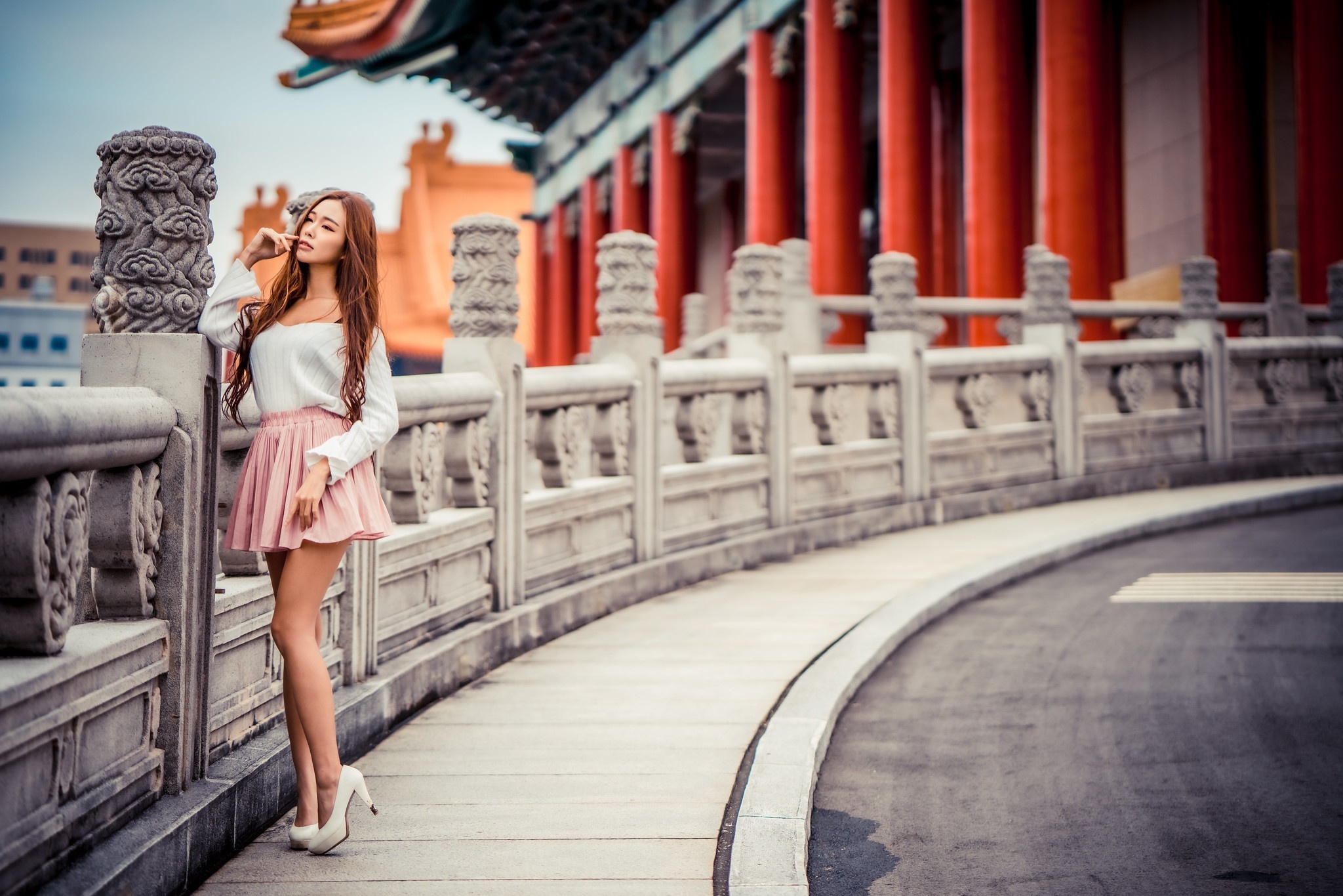 Asian woman in white top and pink skirt posing near a traditional building HD Wallpaper