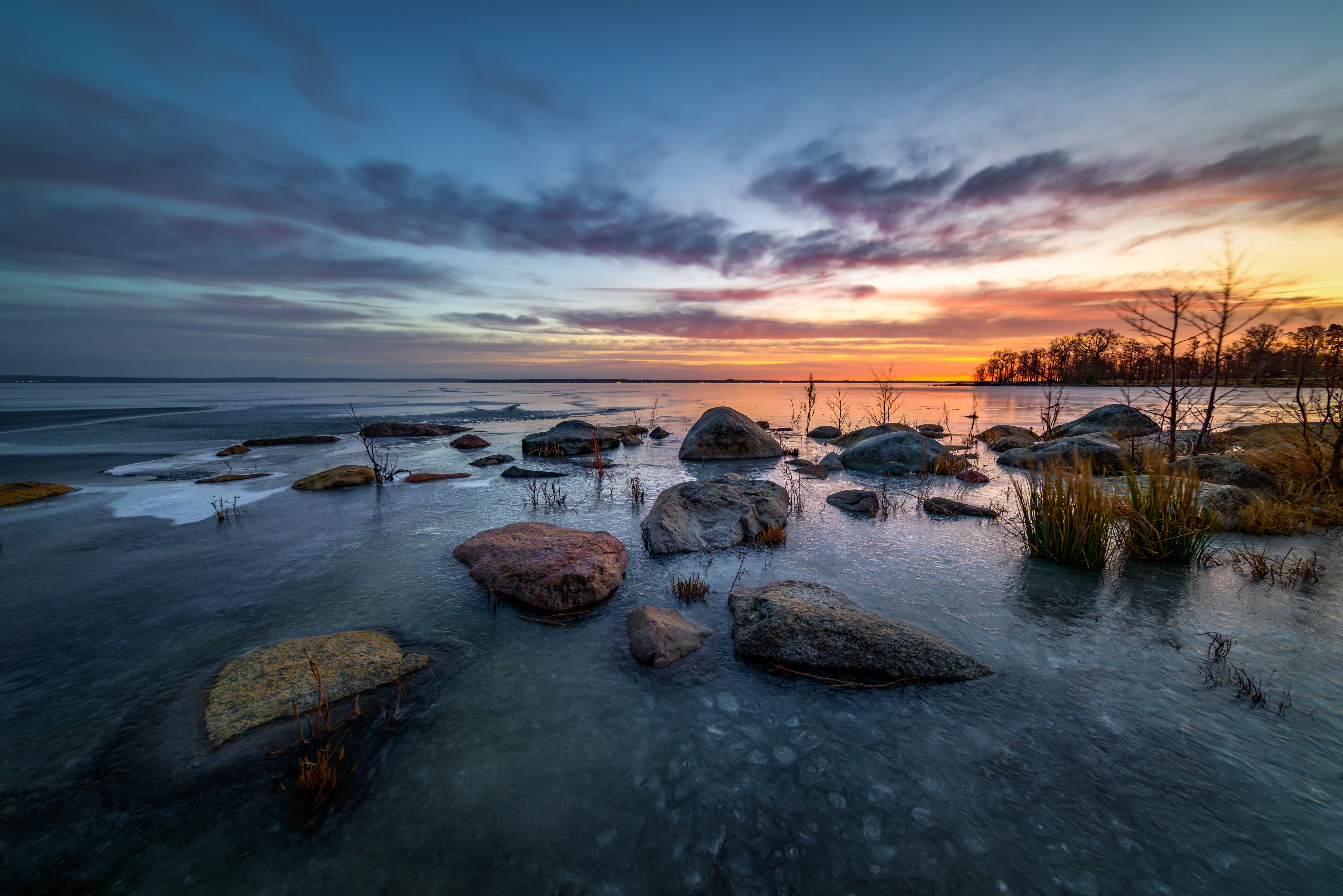 Stones on a frozen lake at sunset in Sweden HD Wallpaper