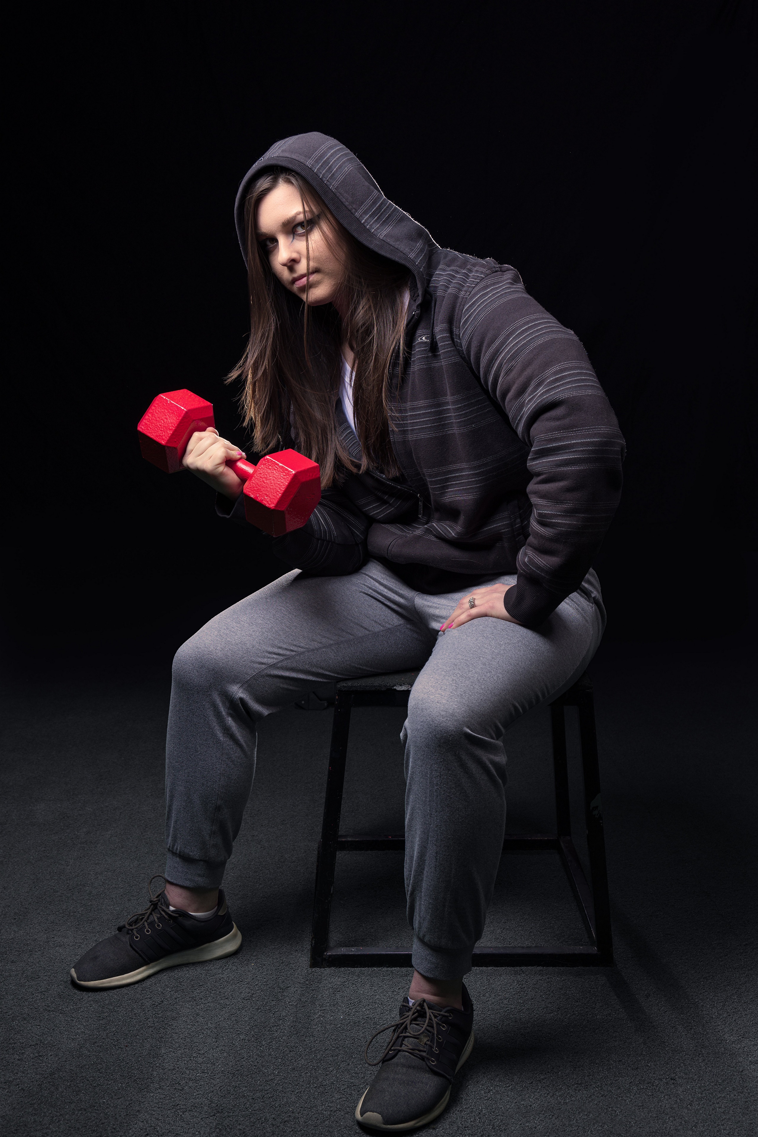 Corinne sitting and lifting a dumbbell HD Phone Wallpaper