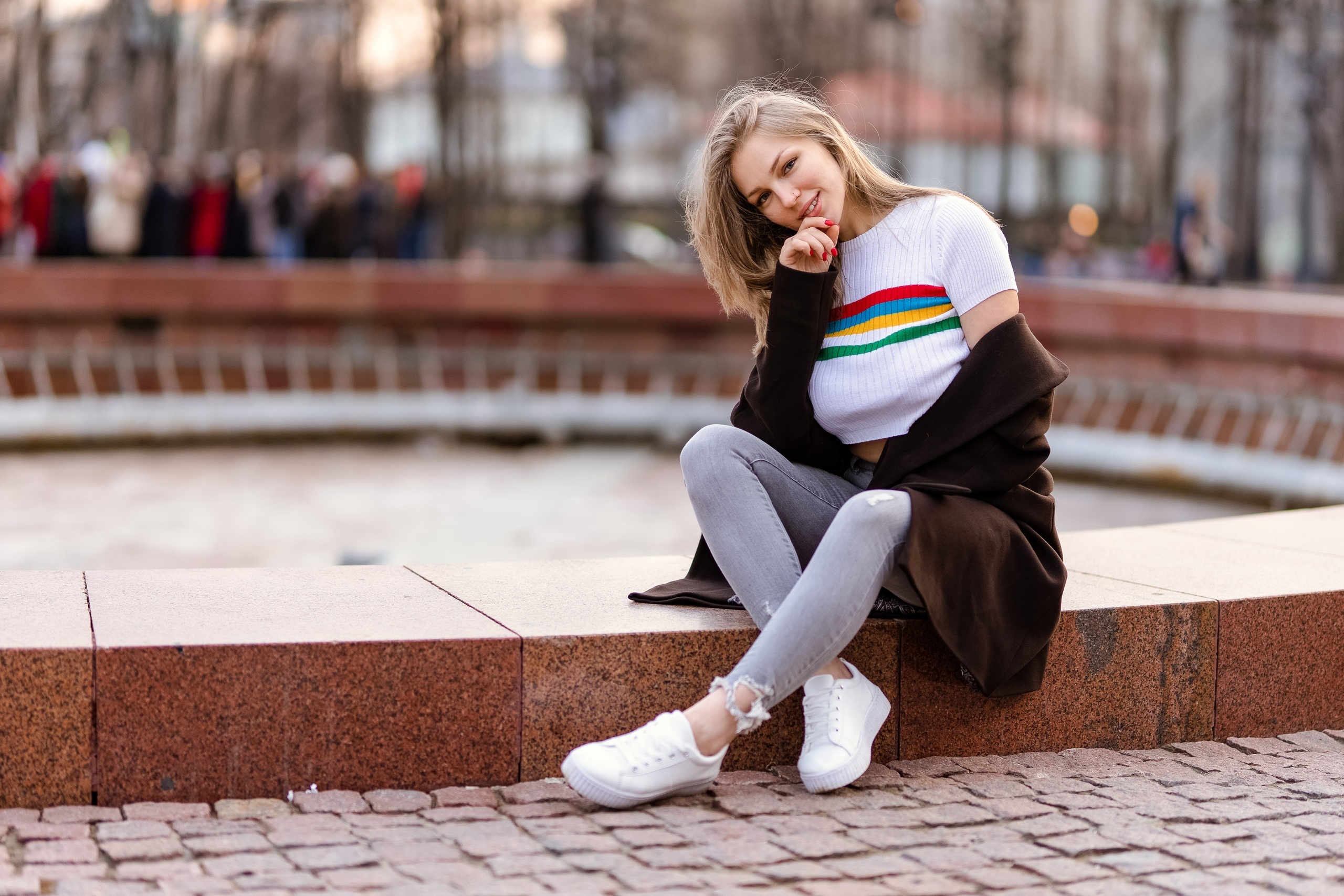 Woman in striped shirt and coat sitting outdoors HD Wallpaper