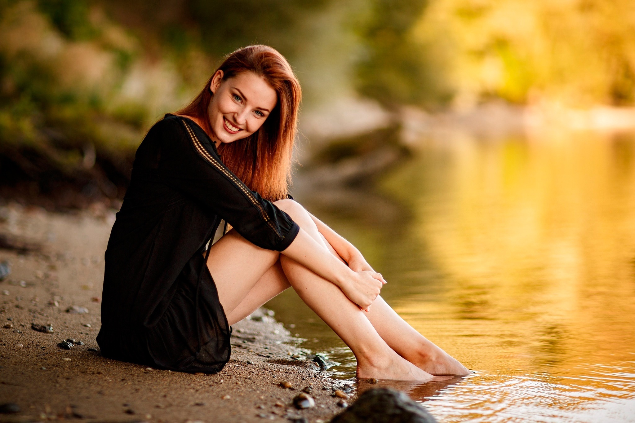 Redhead girl in black dress sitting by the water HD Wallpaper