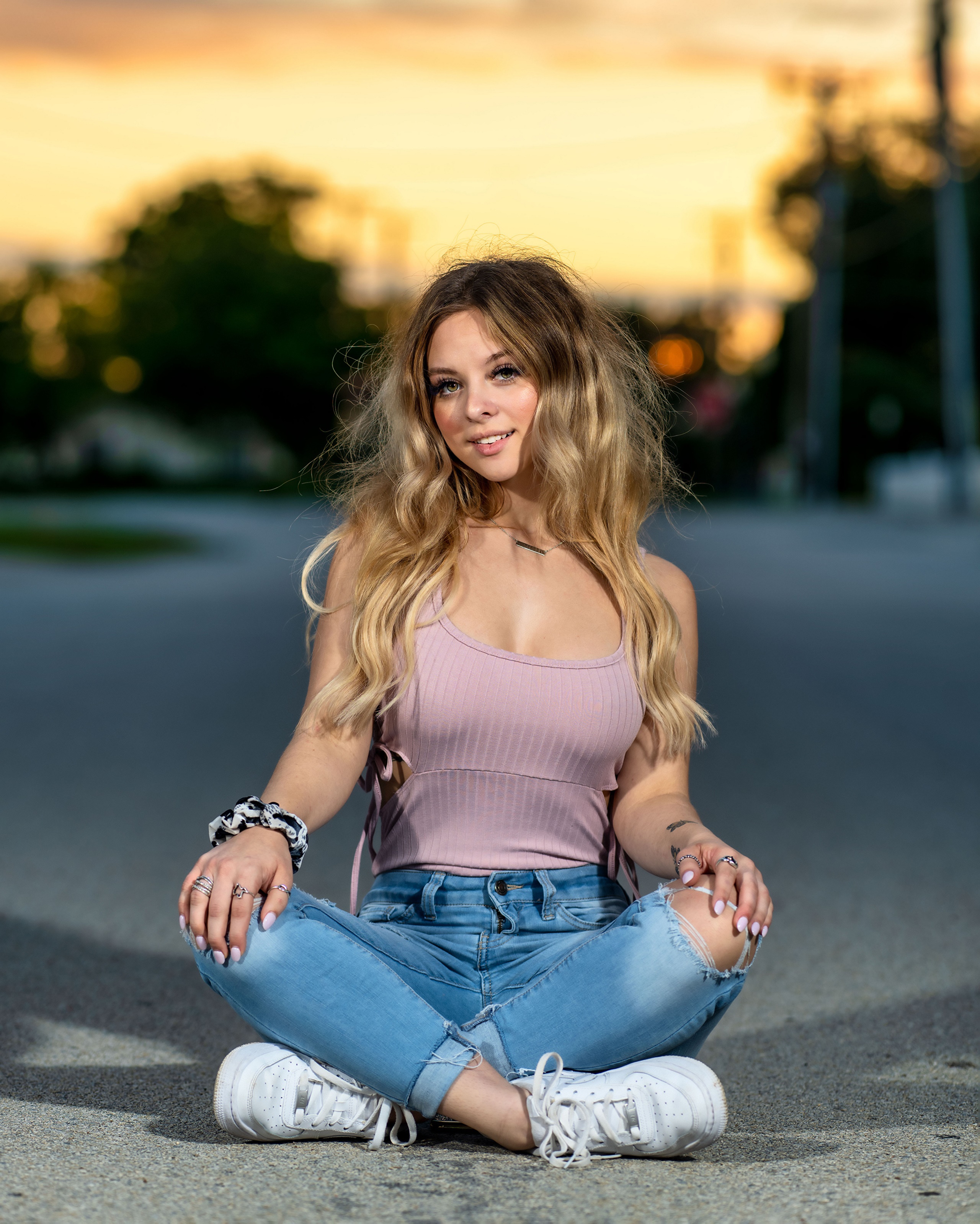 Young woman sitting in lotus position on street HD Phone Wallpaper
