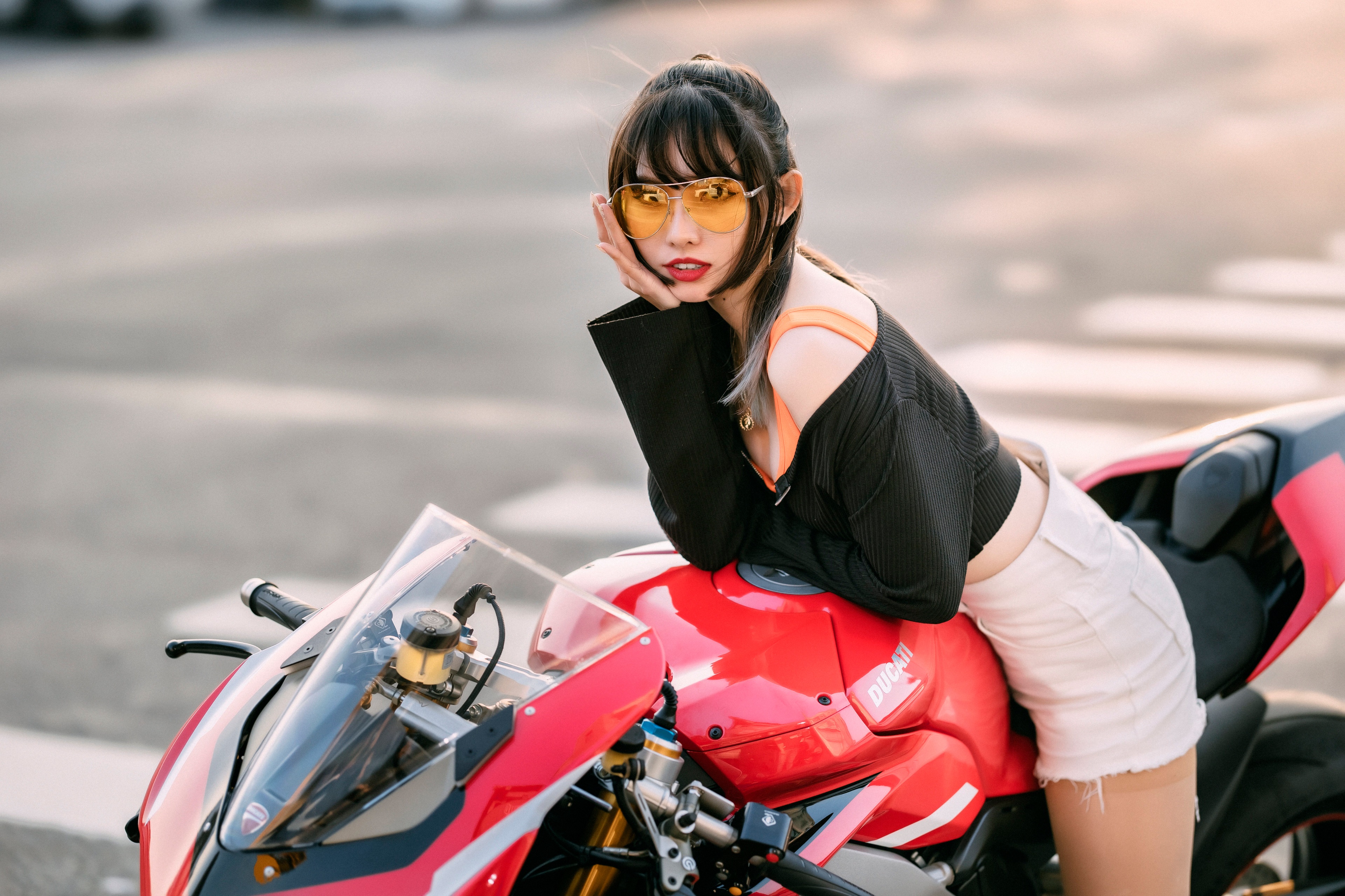 Asian woman with glasses on a red Ducati motorcycle HD Wallpaper