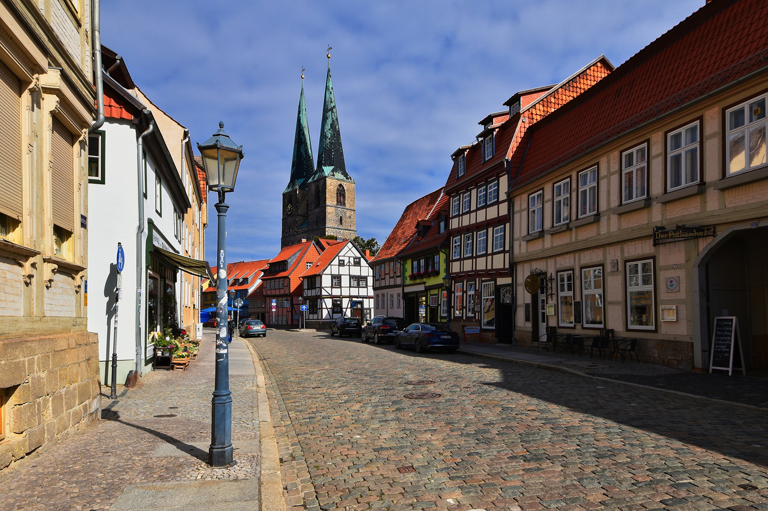 Street in Quedlinburg, Germany with historic houses and church towers HD Wallpaper