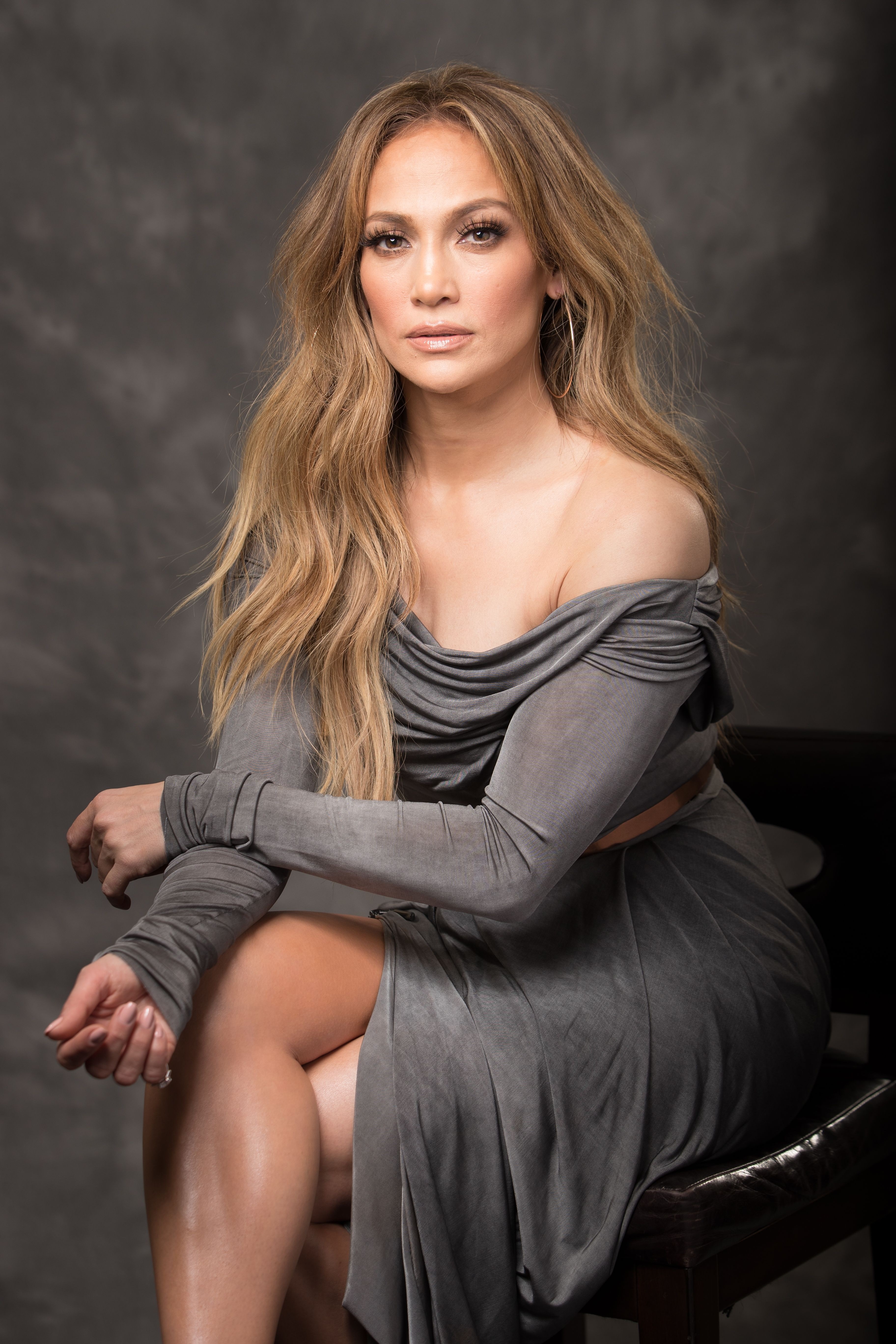 Jennifer Lopez sitting in a grey dress HD Phone Wallpaper