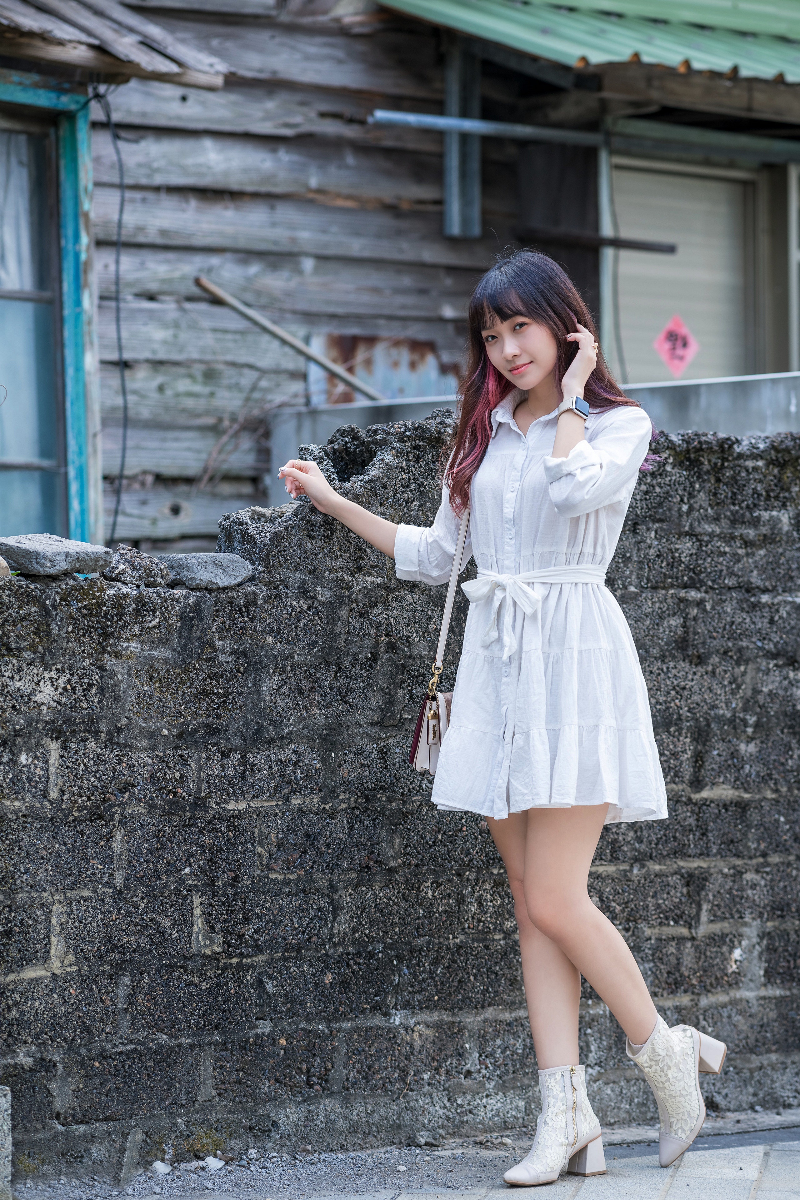 Asian woman in white dress posing by a stone wall HD Phone Wallpaper