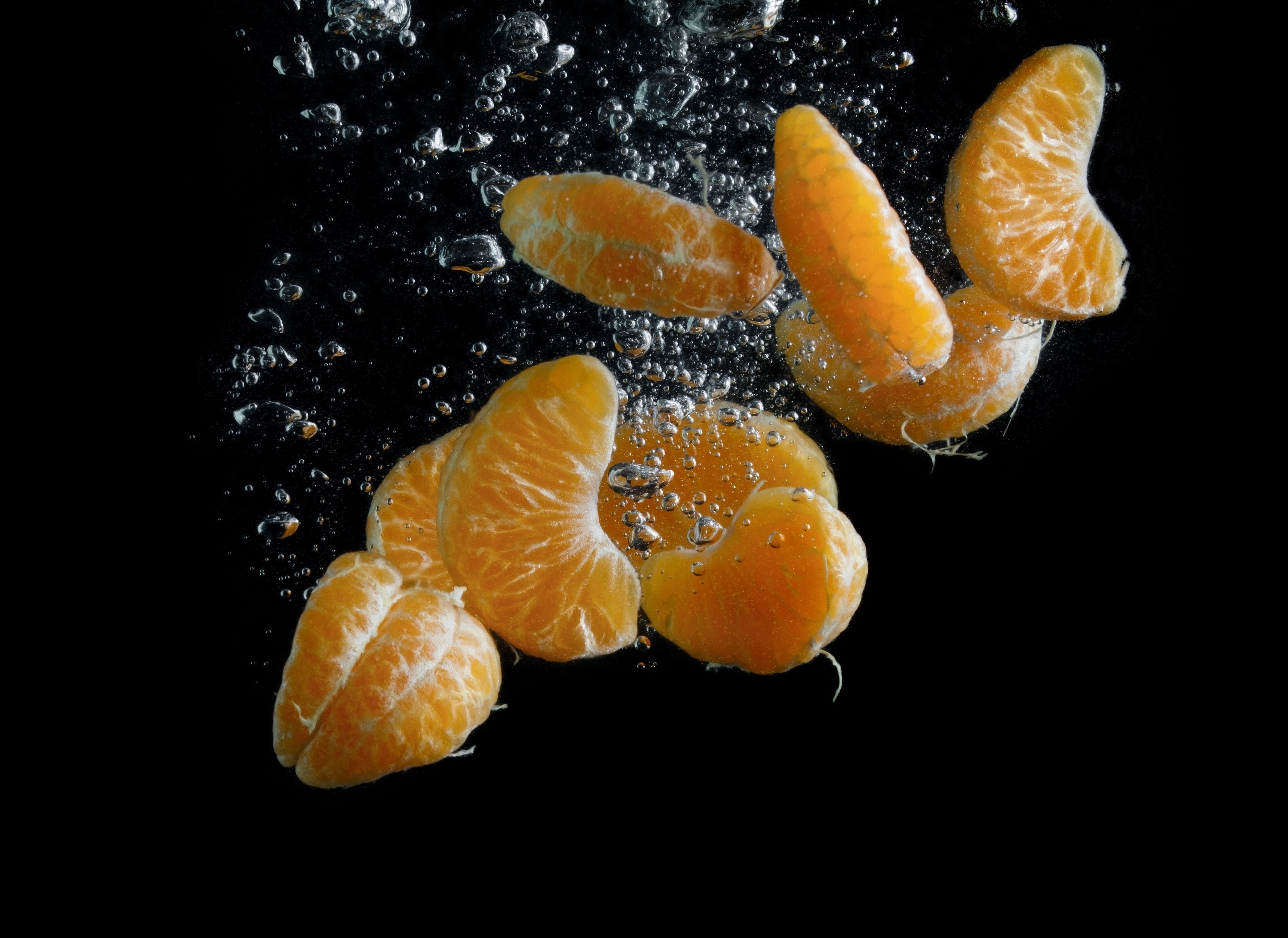 Mandarine pieces in water with bubbles HD Wallpaper