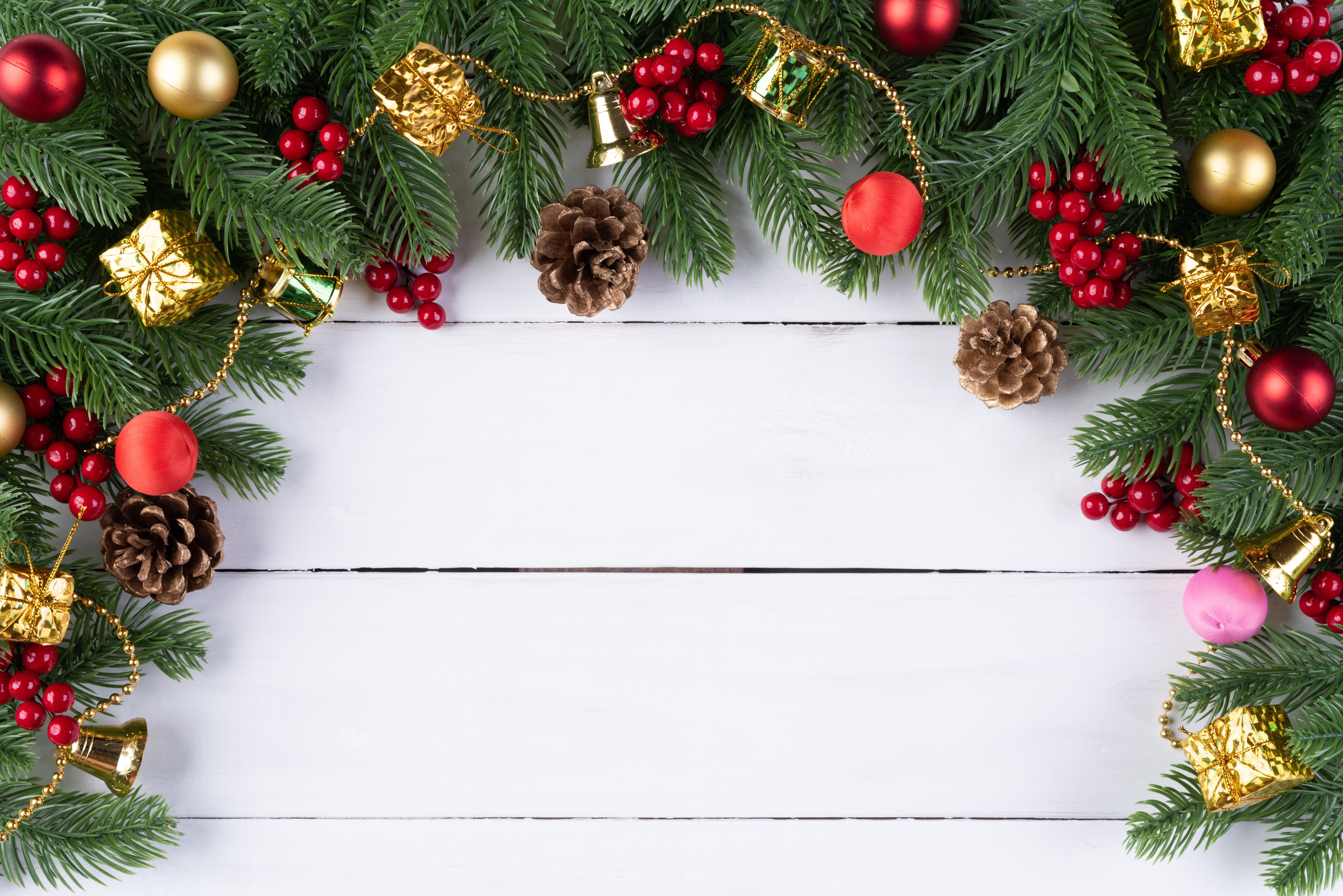 Christmas branches with ornaments and pine cones on white wood HD Wallpaper