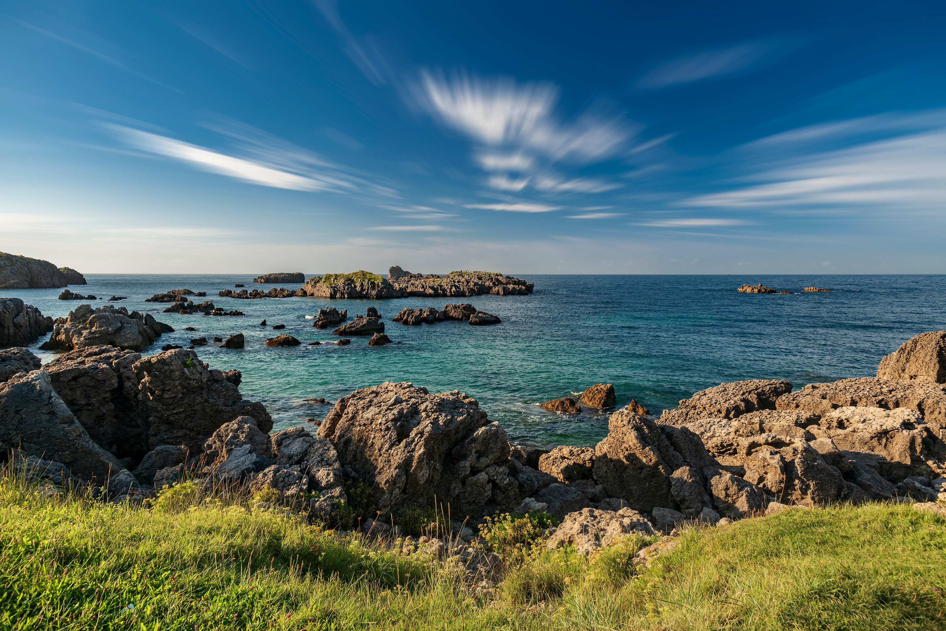 Rocky coast of Cantabria, Spain under a blue sky HD Wallpaper