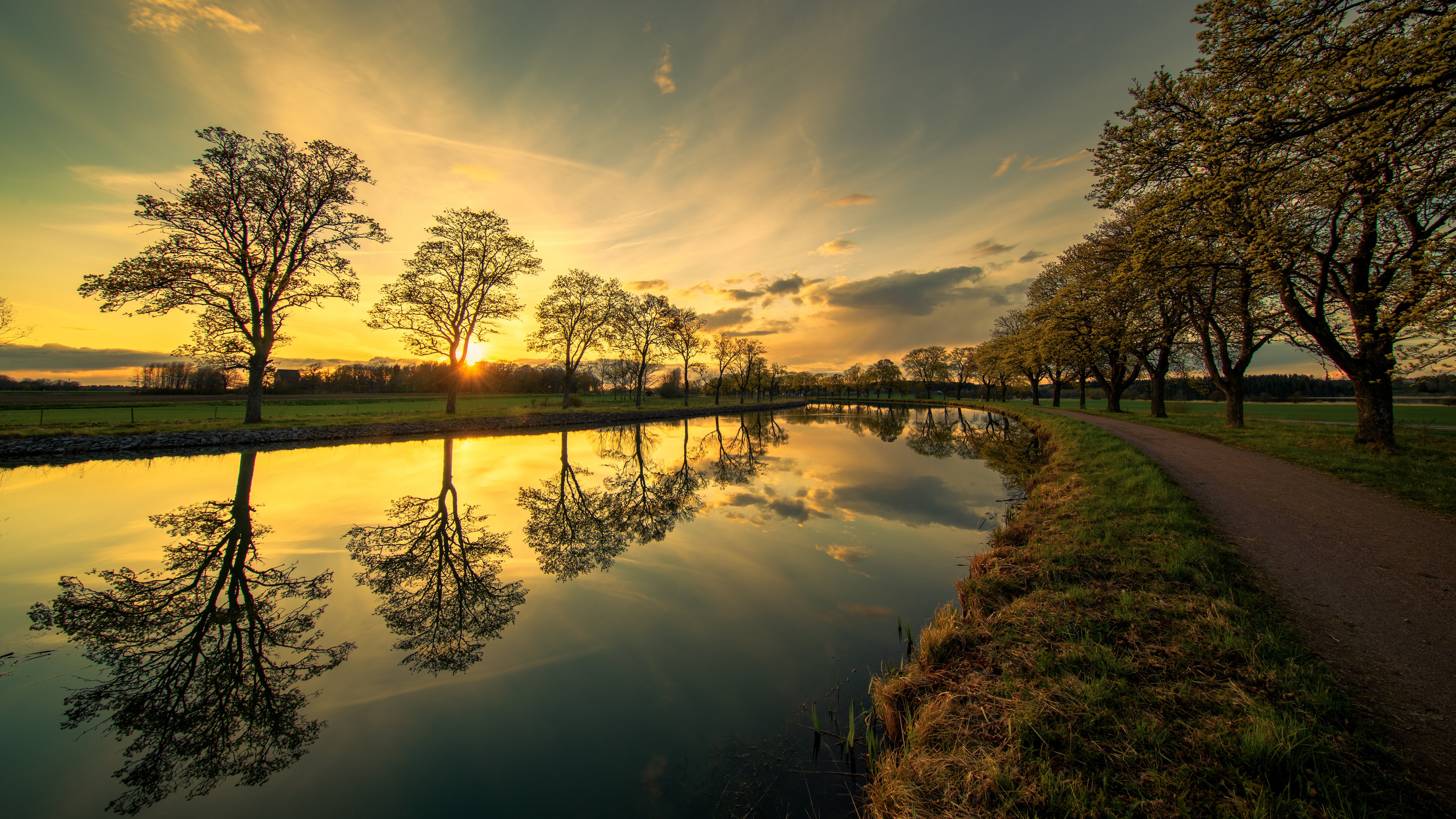 Canal with trees reflecting at sunset in Sweden HD Wallpaper