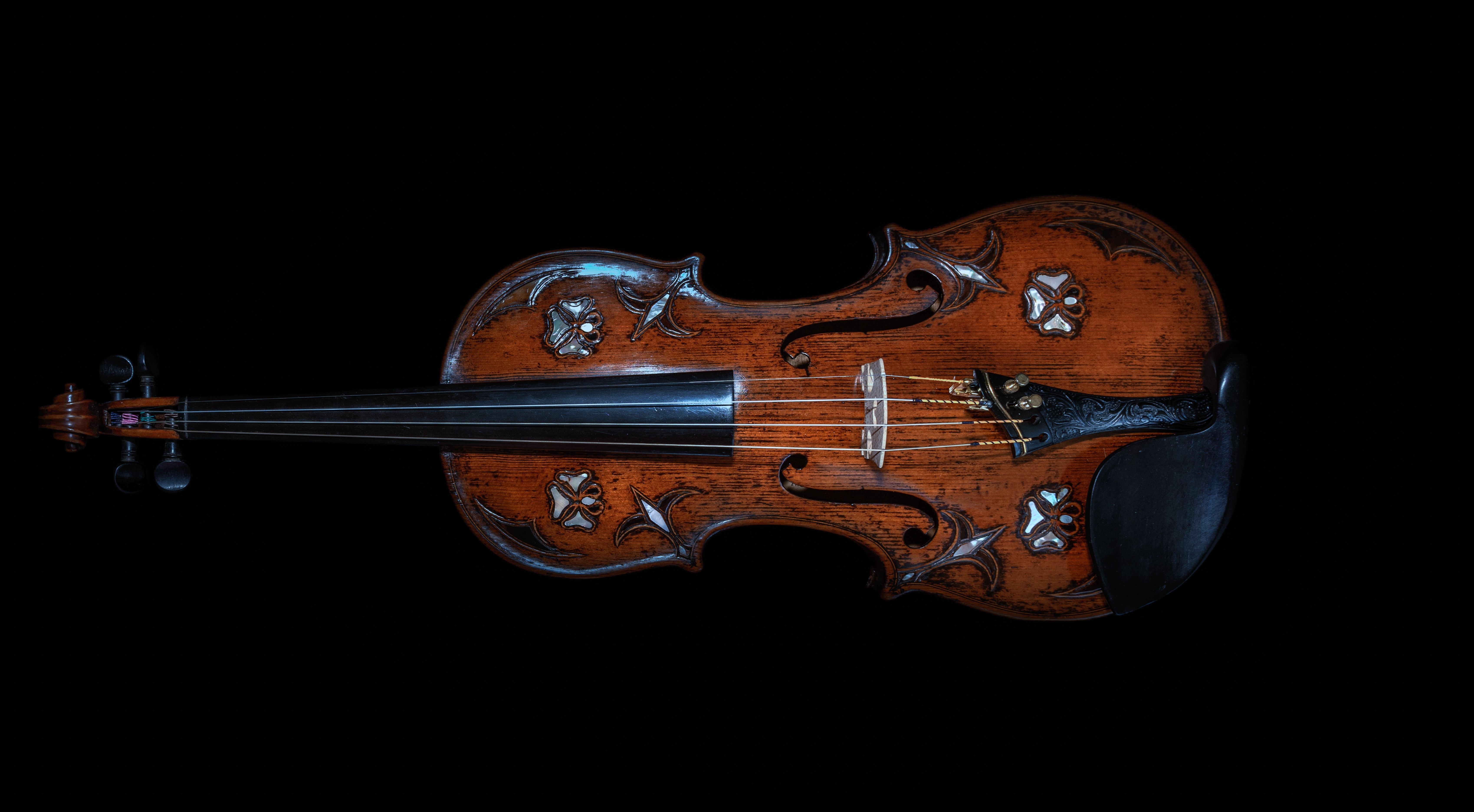Violin with ornate inlay on black background HD Wallpaper