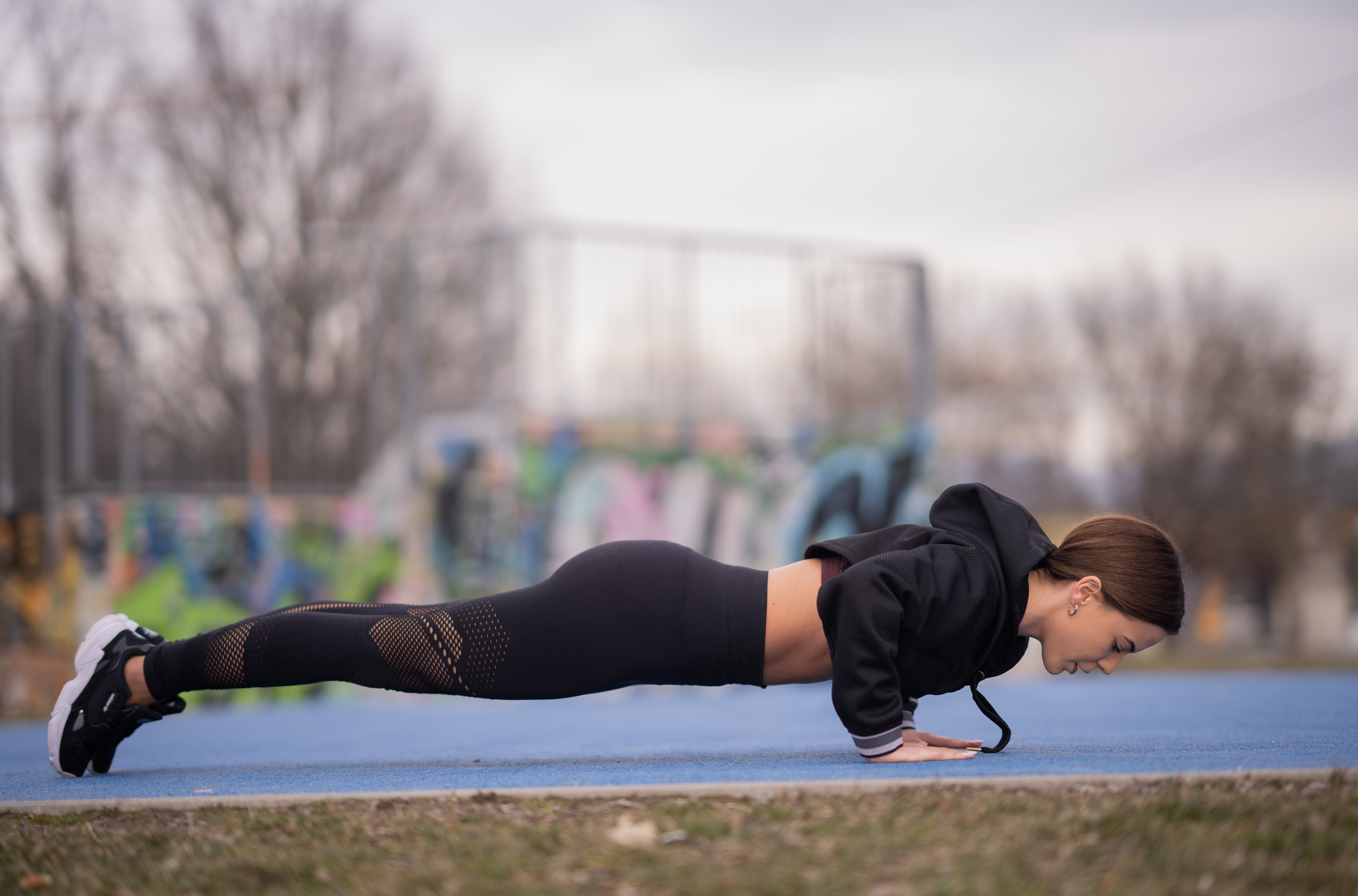Sarah doing push-ups on a blue athletic field HD Wallpaper