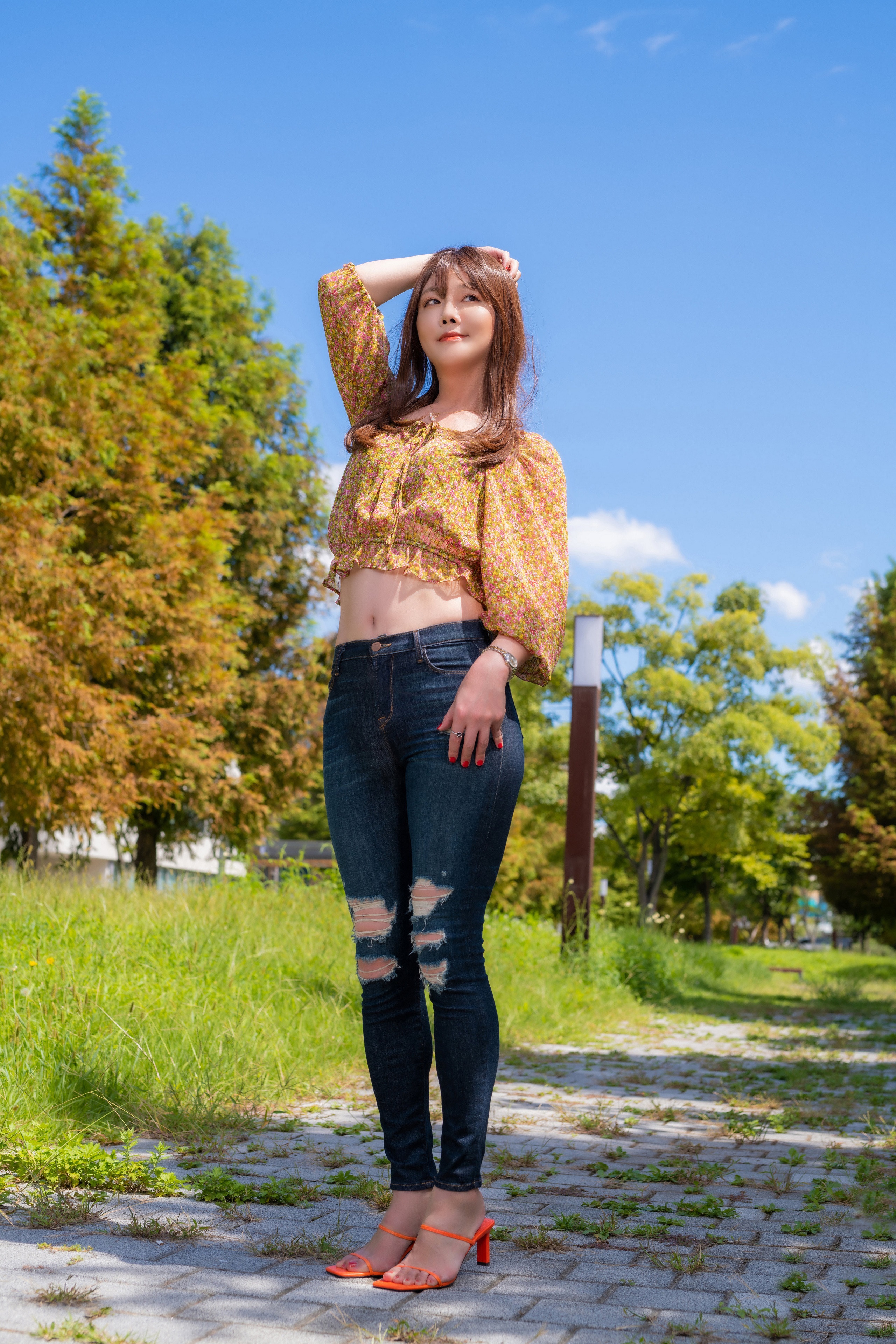 Asian woman in floral crop top and ripped jeans posing outdoors HD Phone Wallpaper