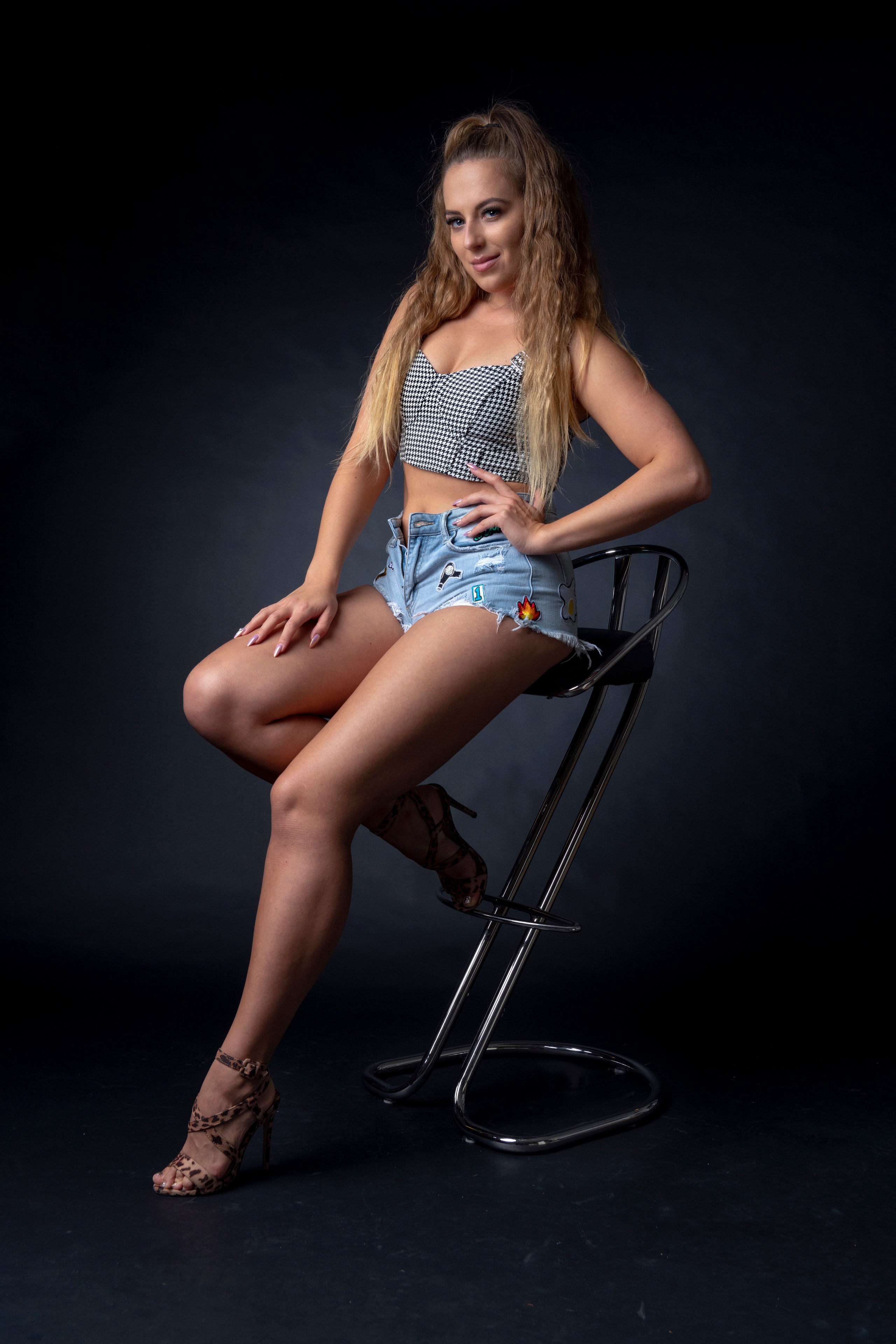 Monika sitting on a stool wearing shorts HD Phone Wallpaper