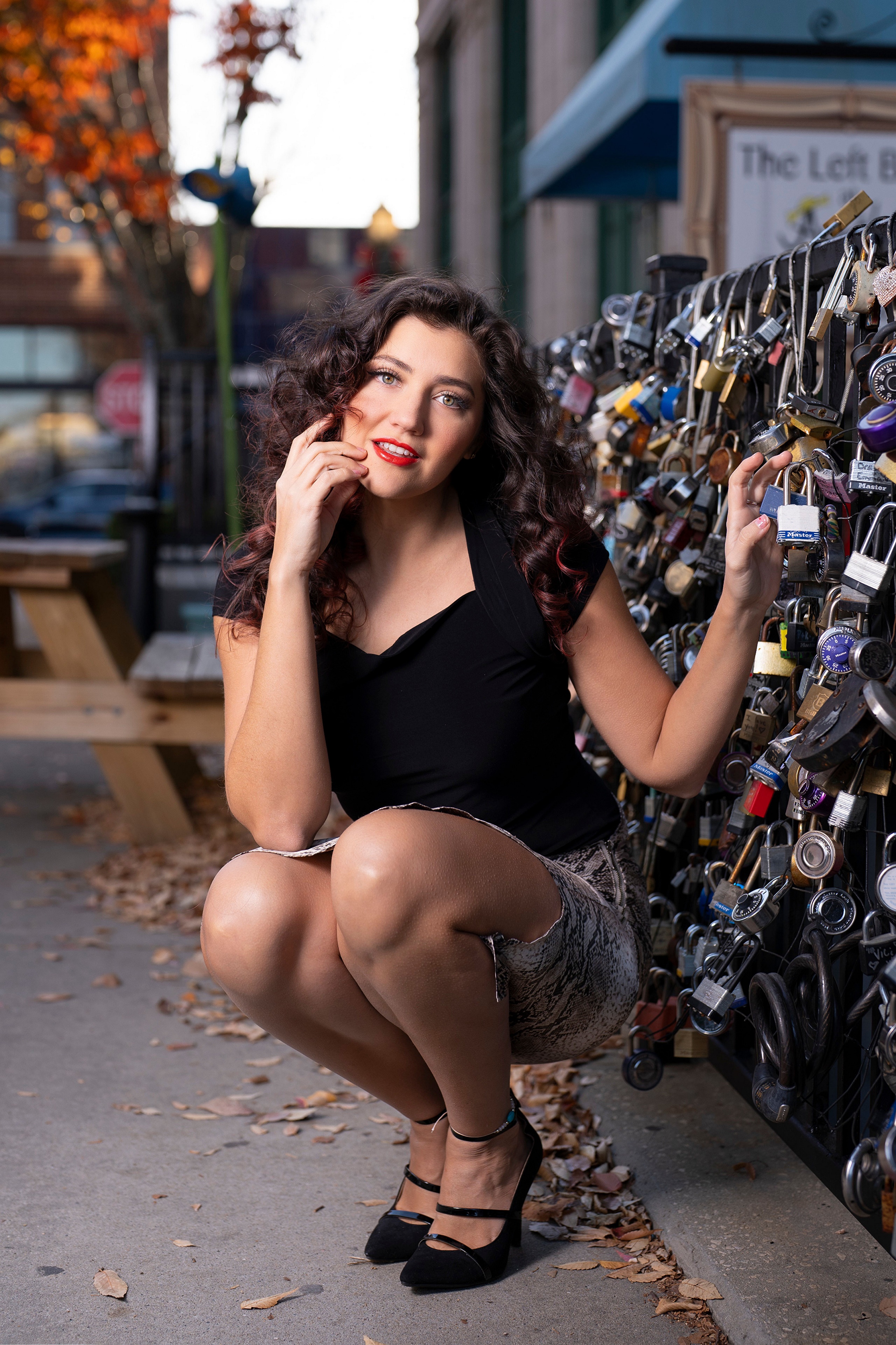 Woman crouching by a fence of padlocks HD Phone Wallpaper