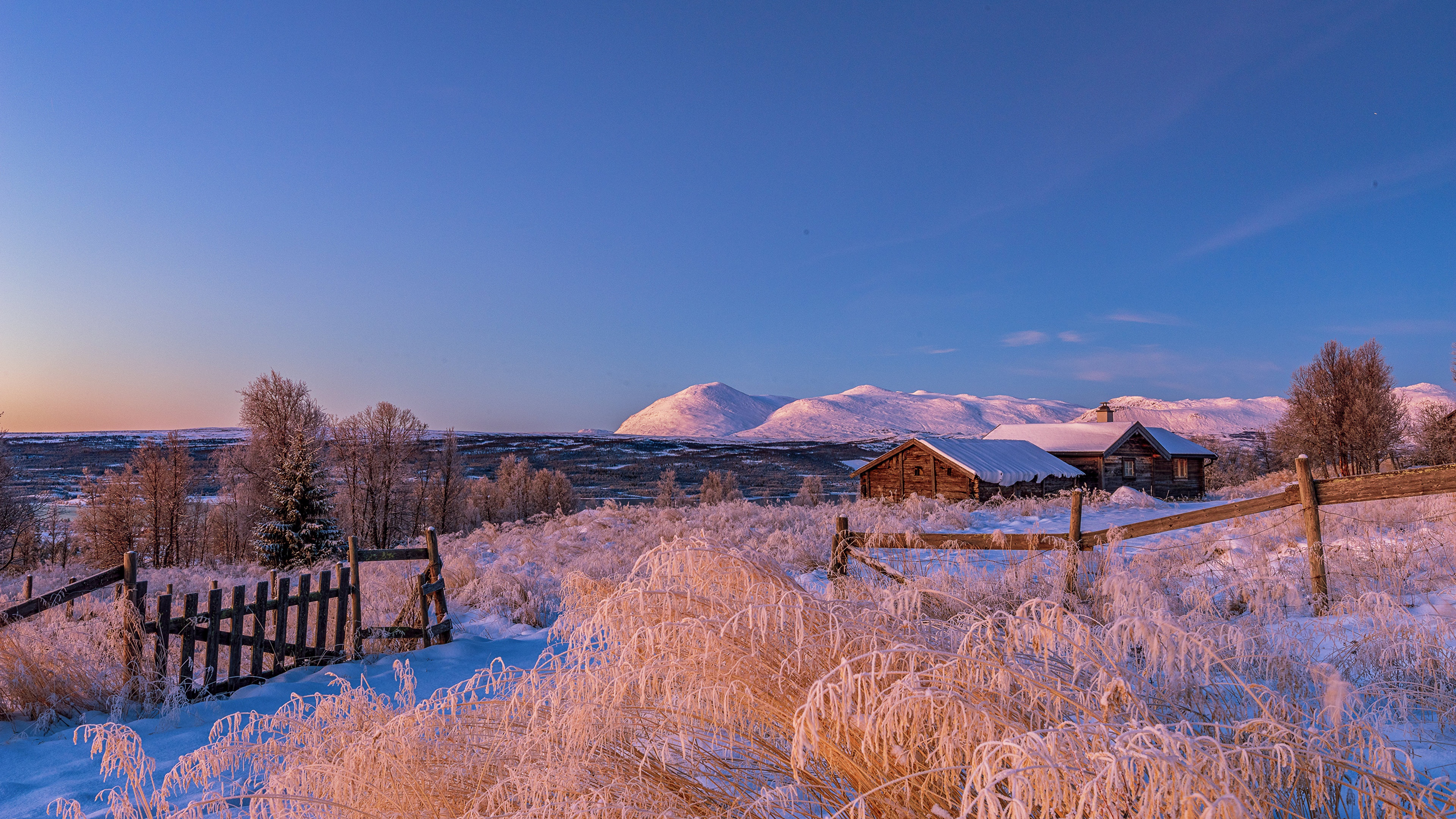 Snowy landscape with wooden cabins and mountains in Norway HD Wallpaper