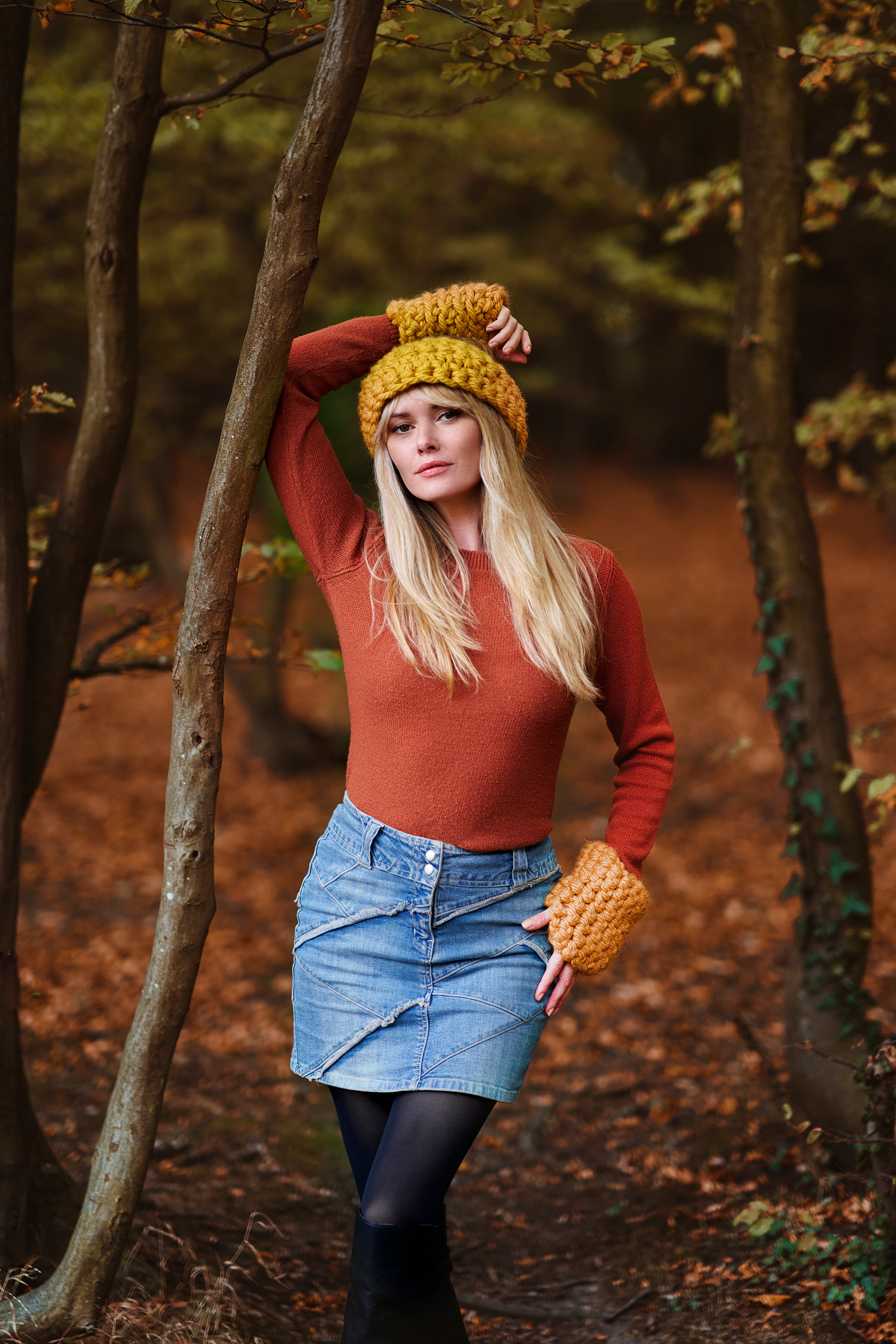 Blonde woman in autumn forest wearing sweater and denim skirt HD Phone Wallpaper