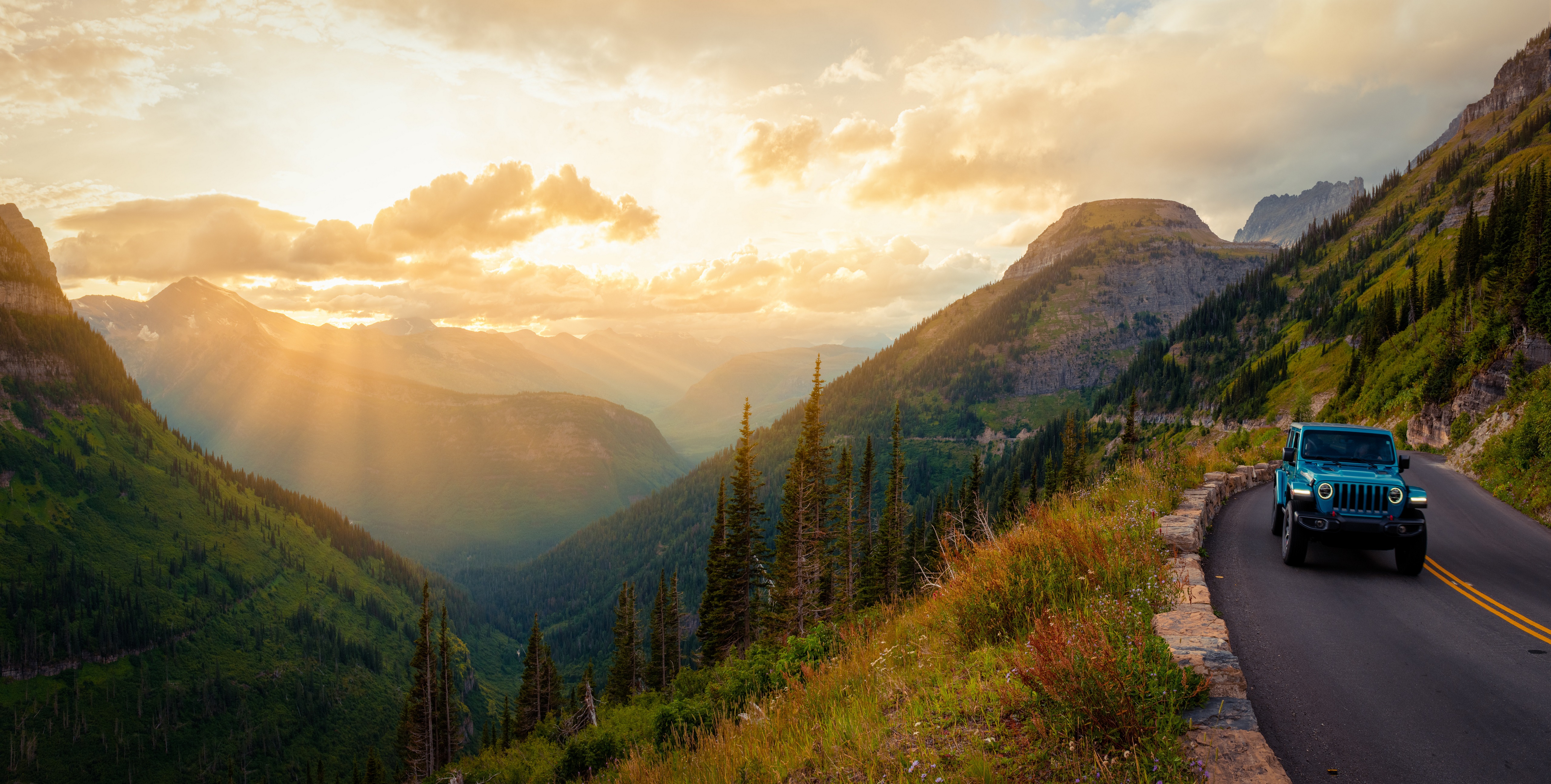 Jeep on a mountain road in Glacier National Park at sunset HD Wallpaper