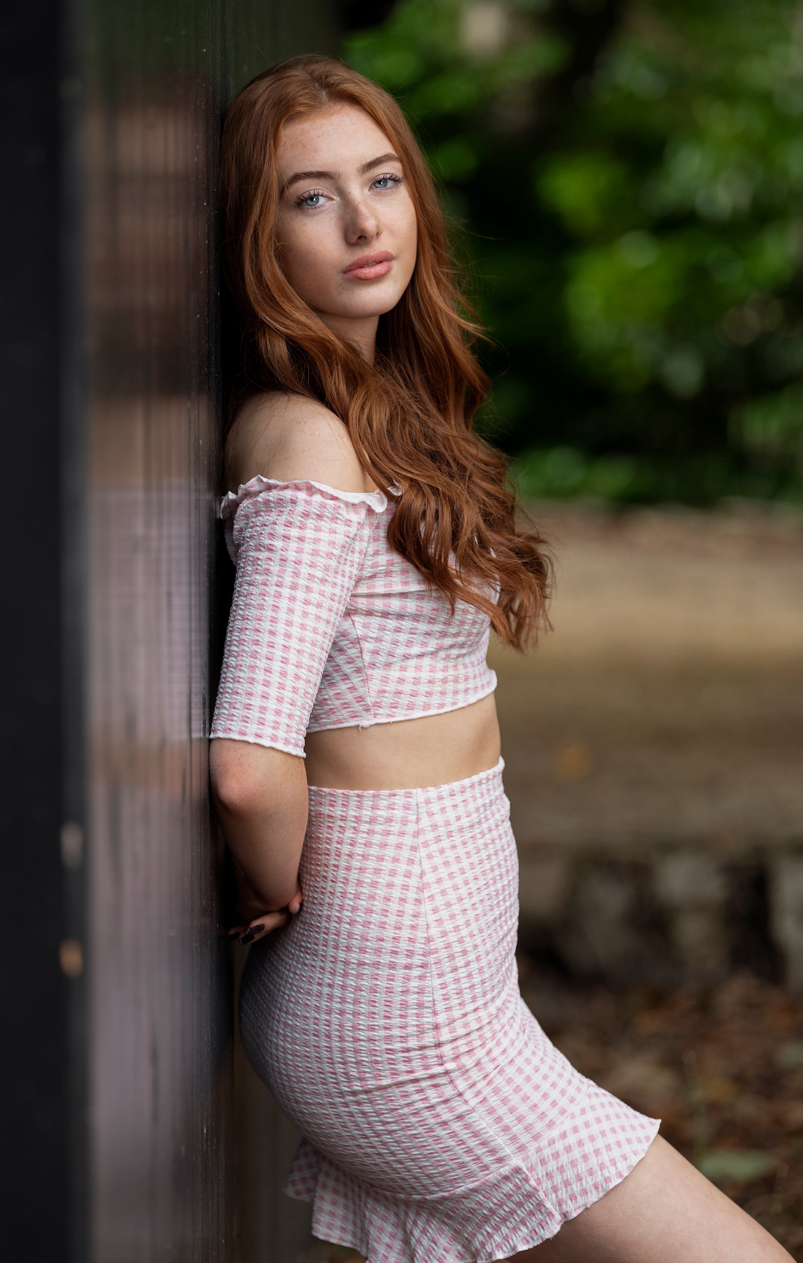 Redhead girl Emilia leaning against a wall HD Phone Wallpaper