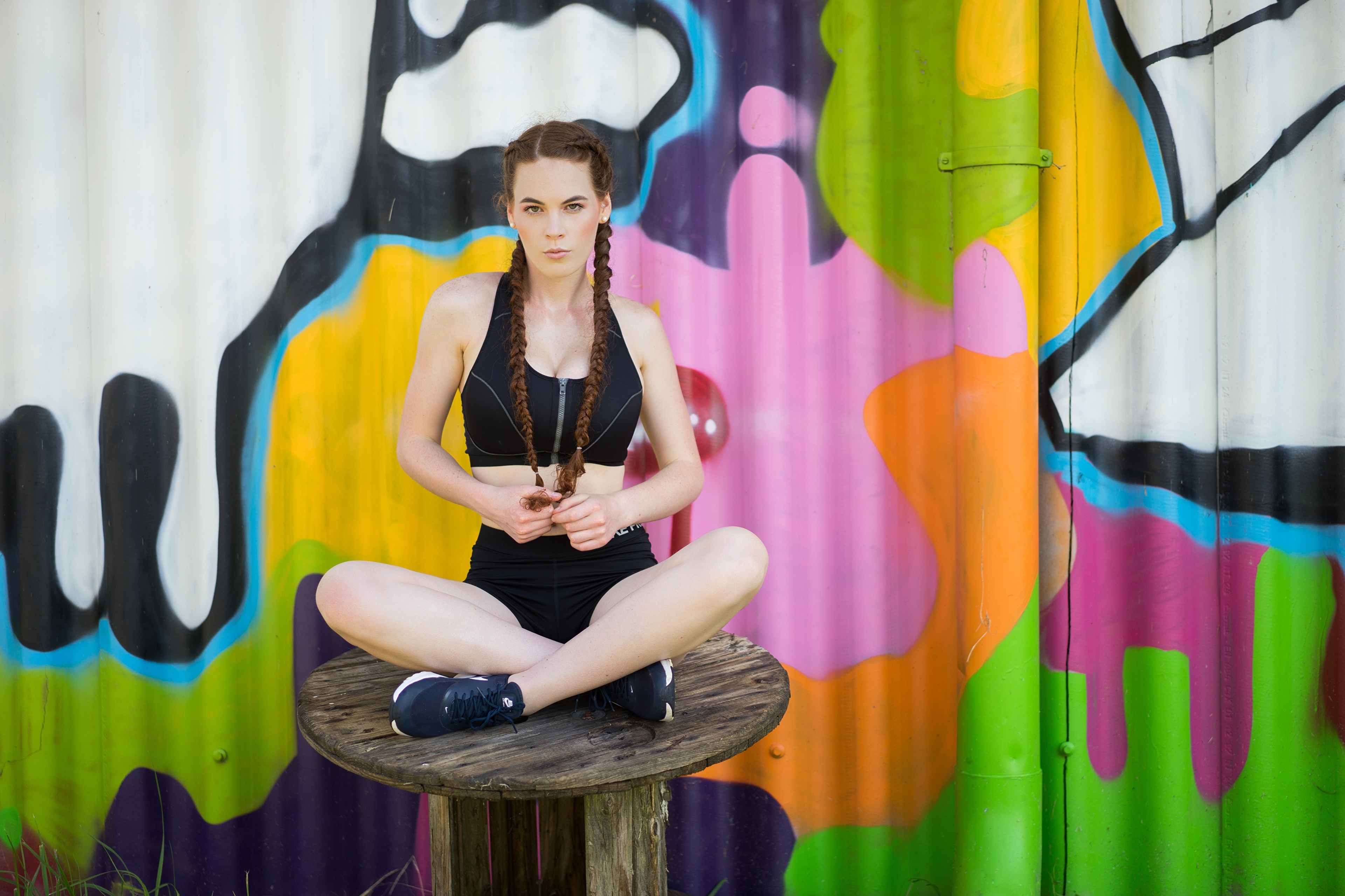 Katja with braided hair sitting in front of graffiti HD Wallpaper