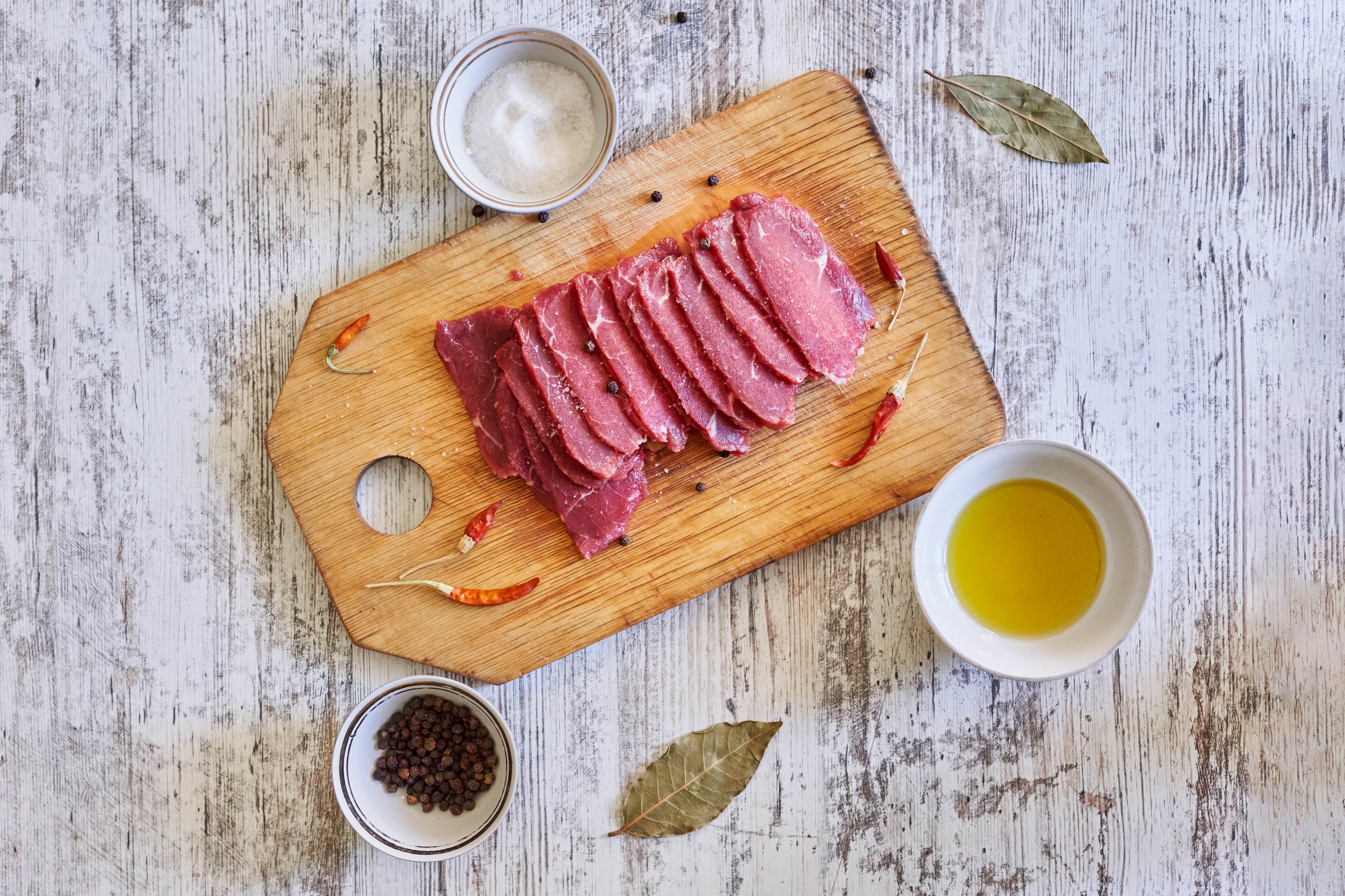 Sliced meat on cutting board with spices and oil HD Wallpaper