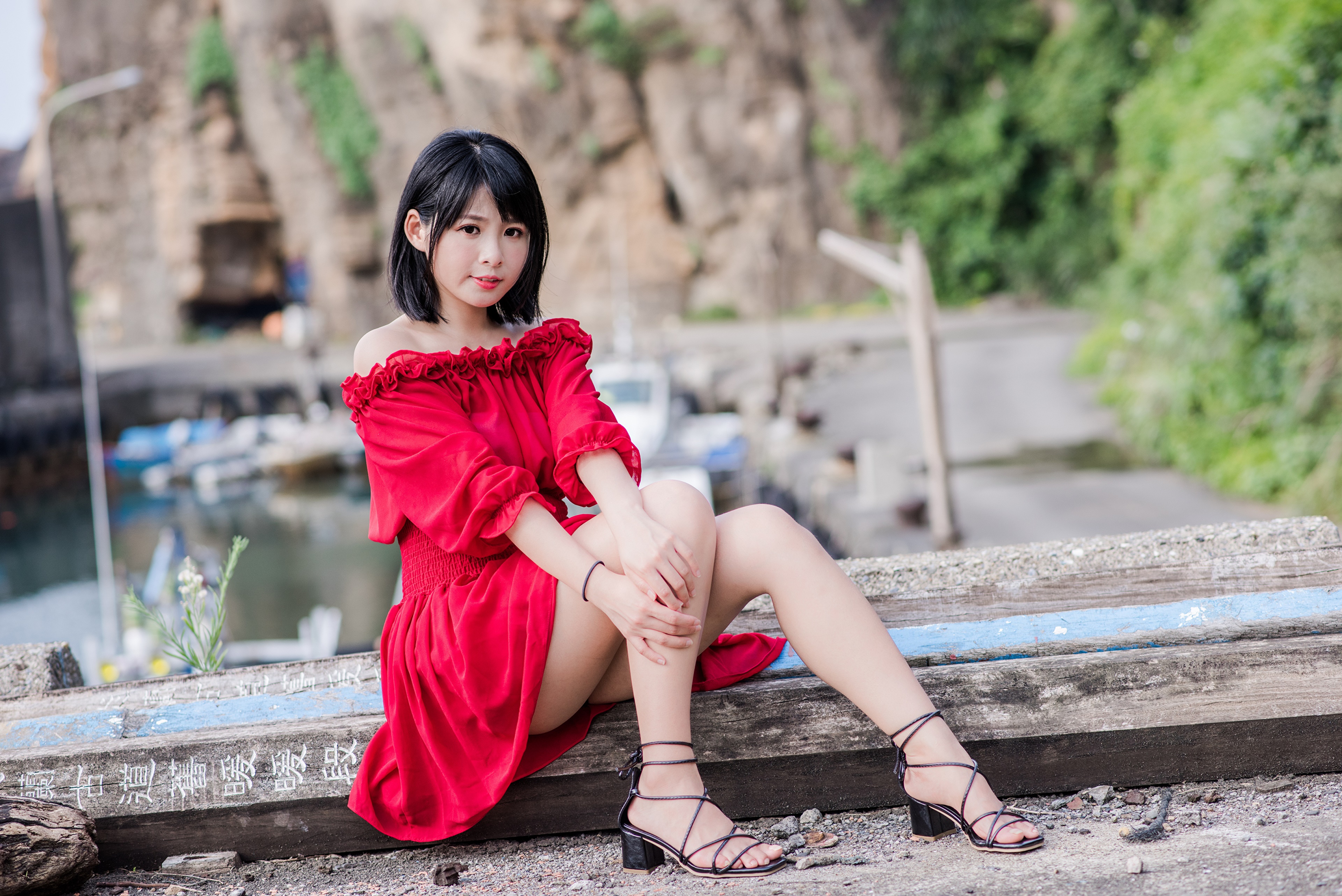 Brunette girl in red dress sitting by the water HD Wallpaper