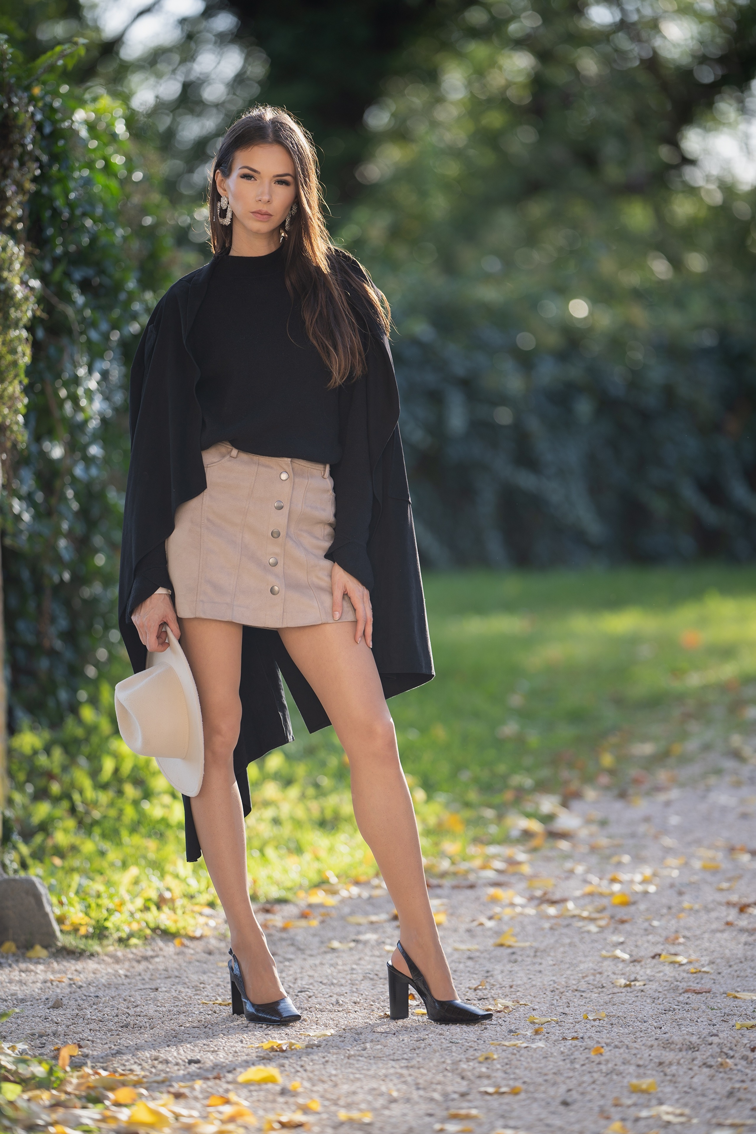 Brunette woman in cloak and skirt holding hat HD Phone Wallpaper