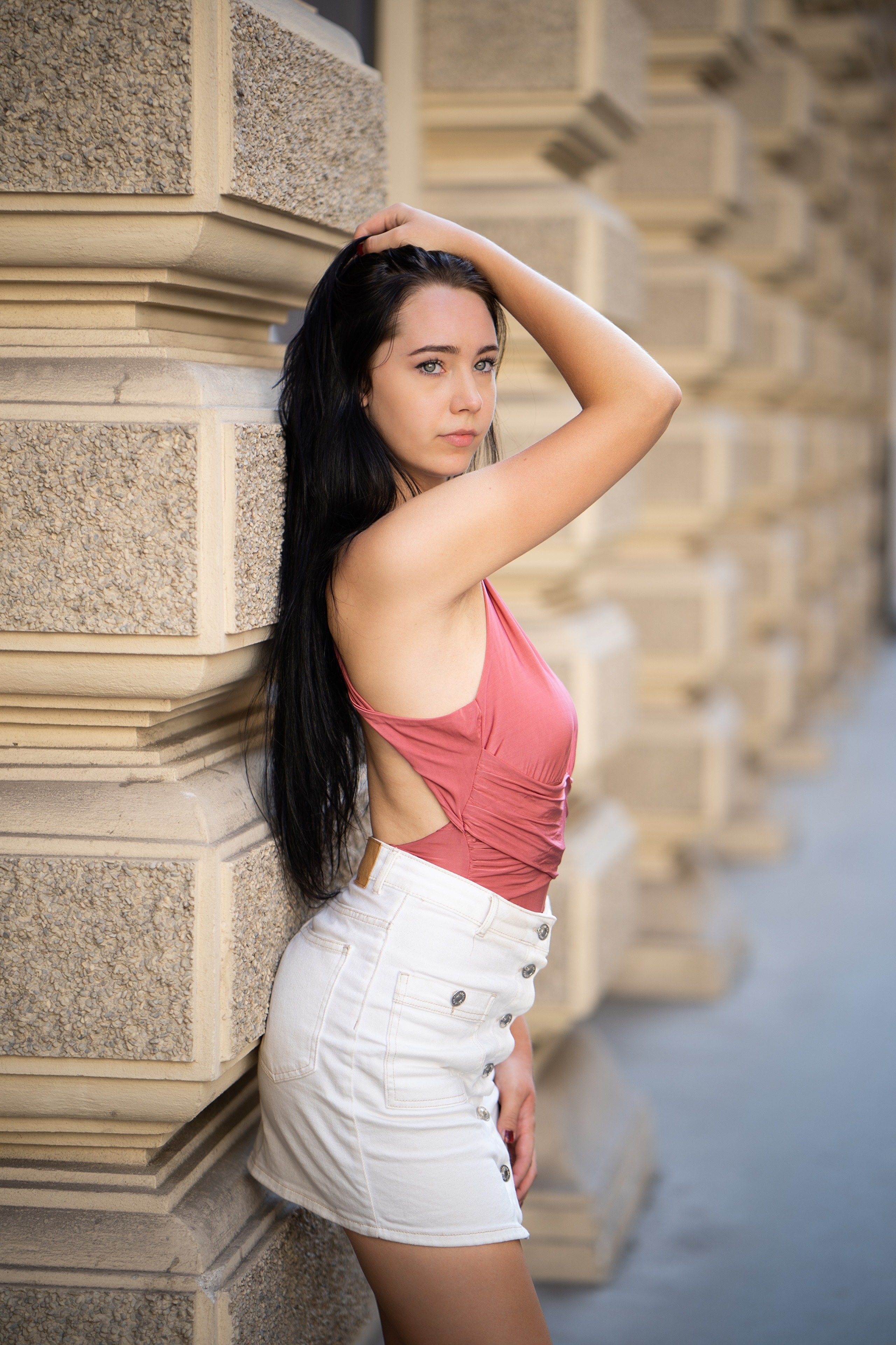 Brunette girl in pink top and white skirt posing HD Phone Wallpaper