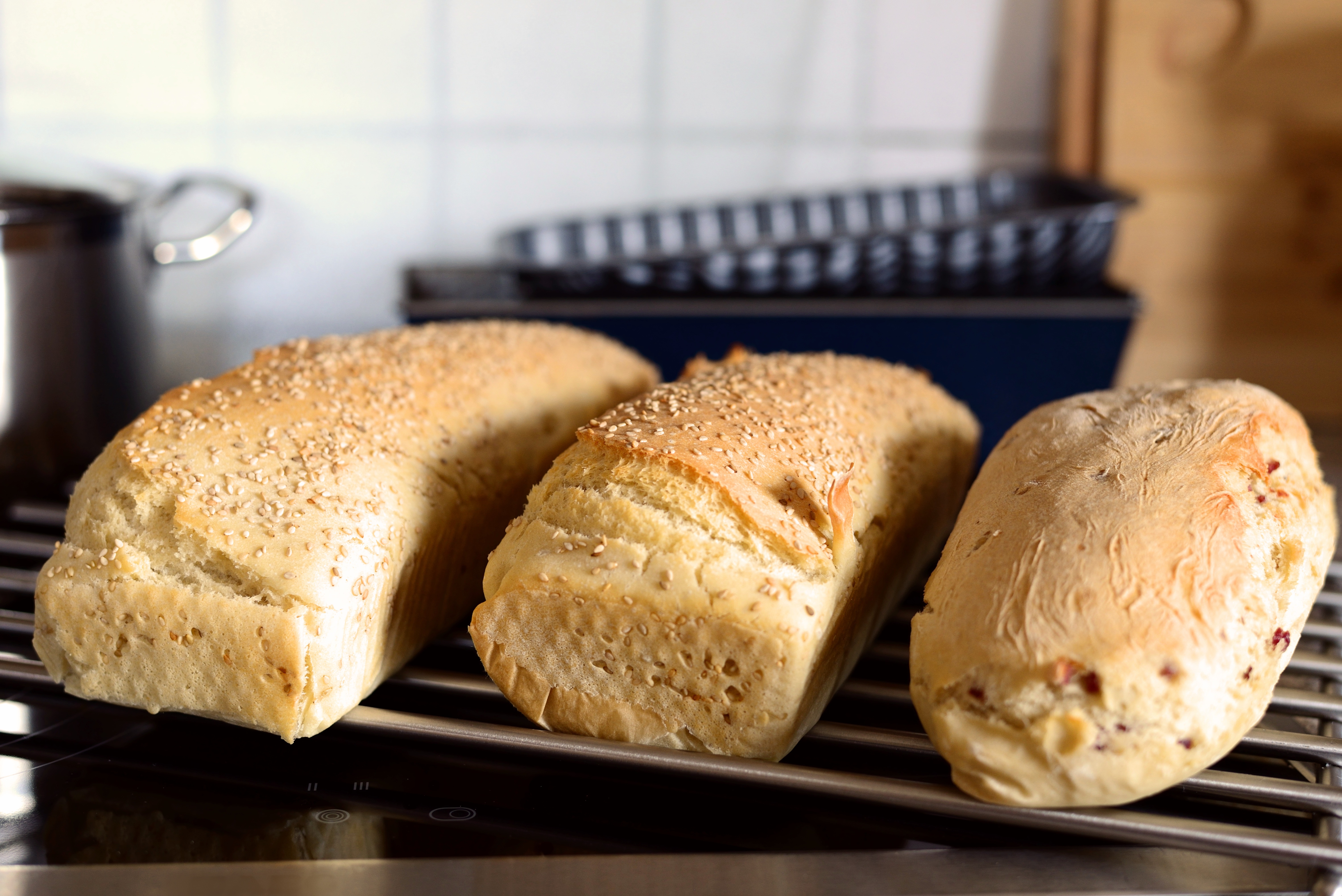 Three loaves of bread on a cooling rack HD Wallpaper