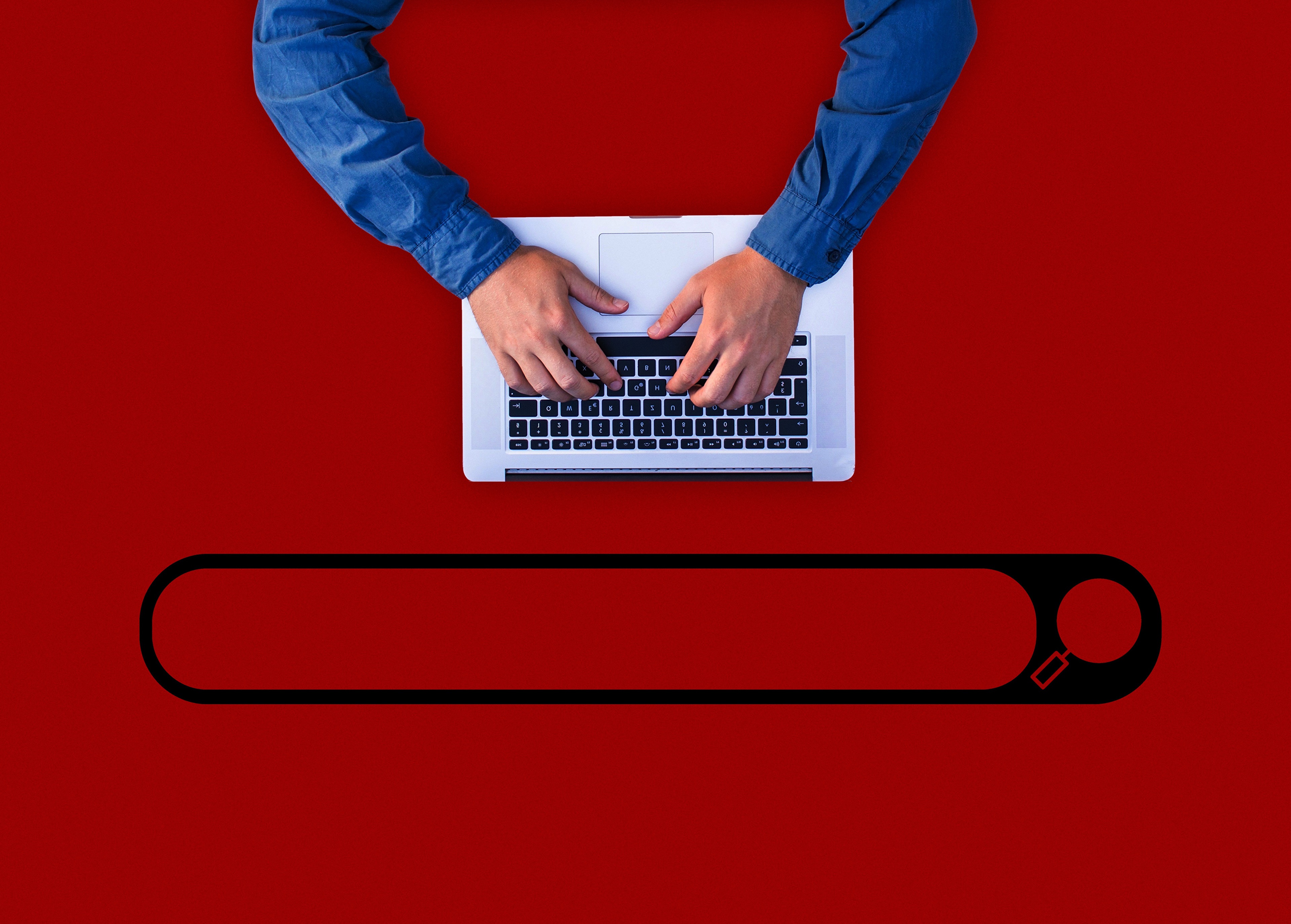 Hands typing on laptop with search bar on red background HD Wallpaper