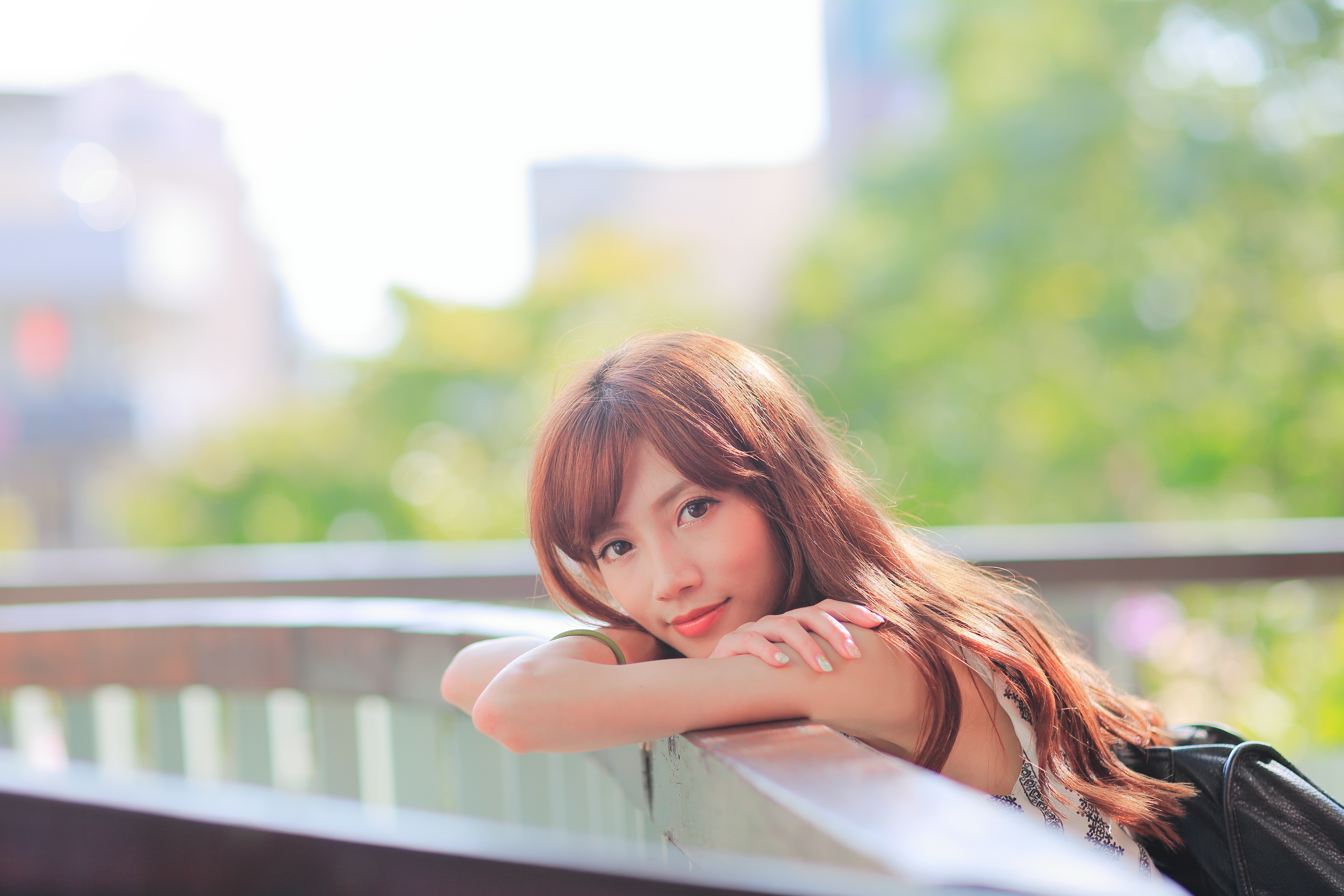 Asian woman with brown hair resting on railing HD Wallpaper