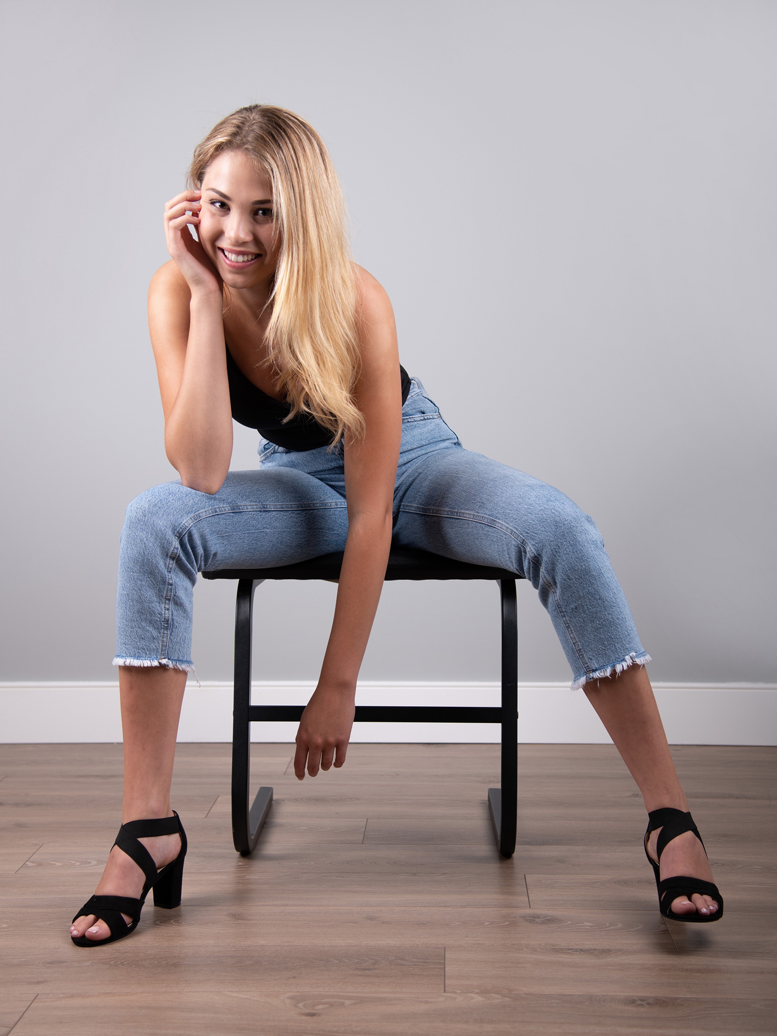 Mia Chagnon sitting in jeans and heels HD Phone Wallpaper