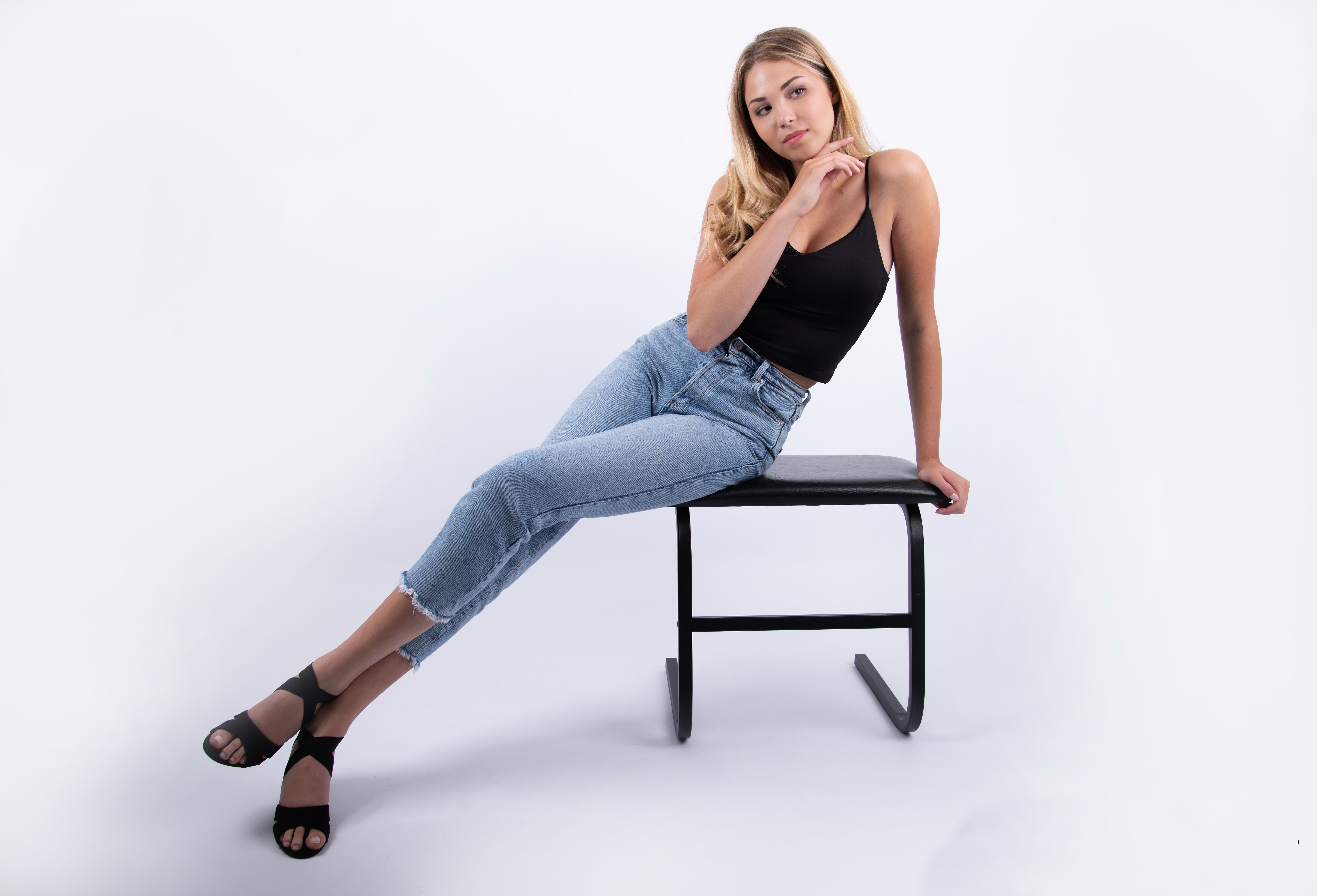 Blonde girl in jeans and singlet posing on a stool HD Wallpaper