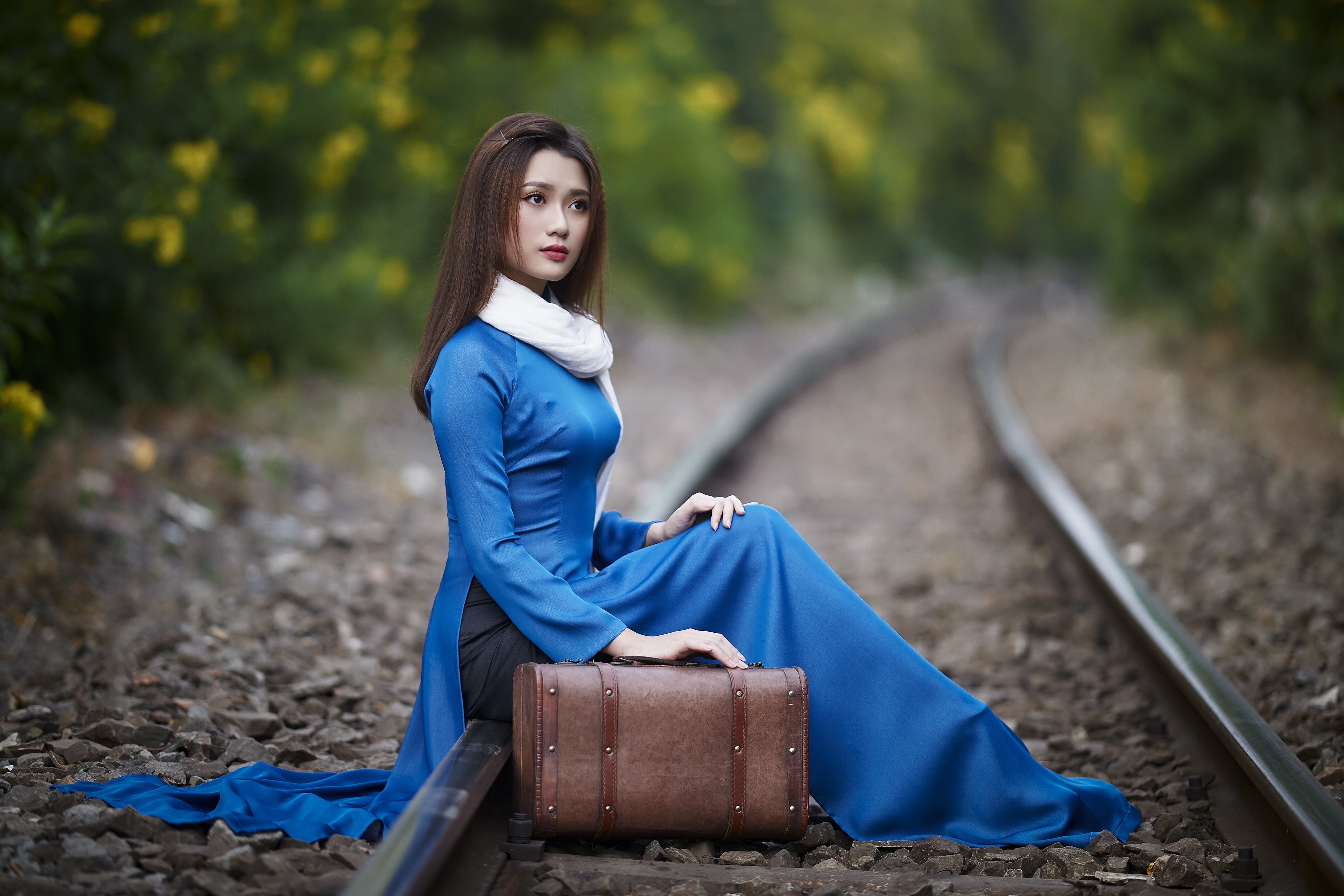 Asian woman with suitcase on train tracks HD Wallpaper