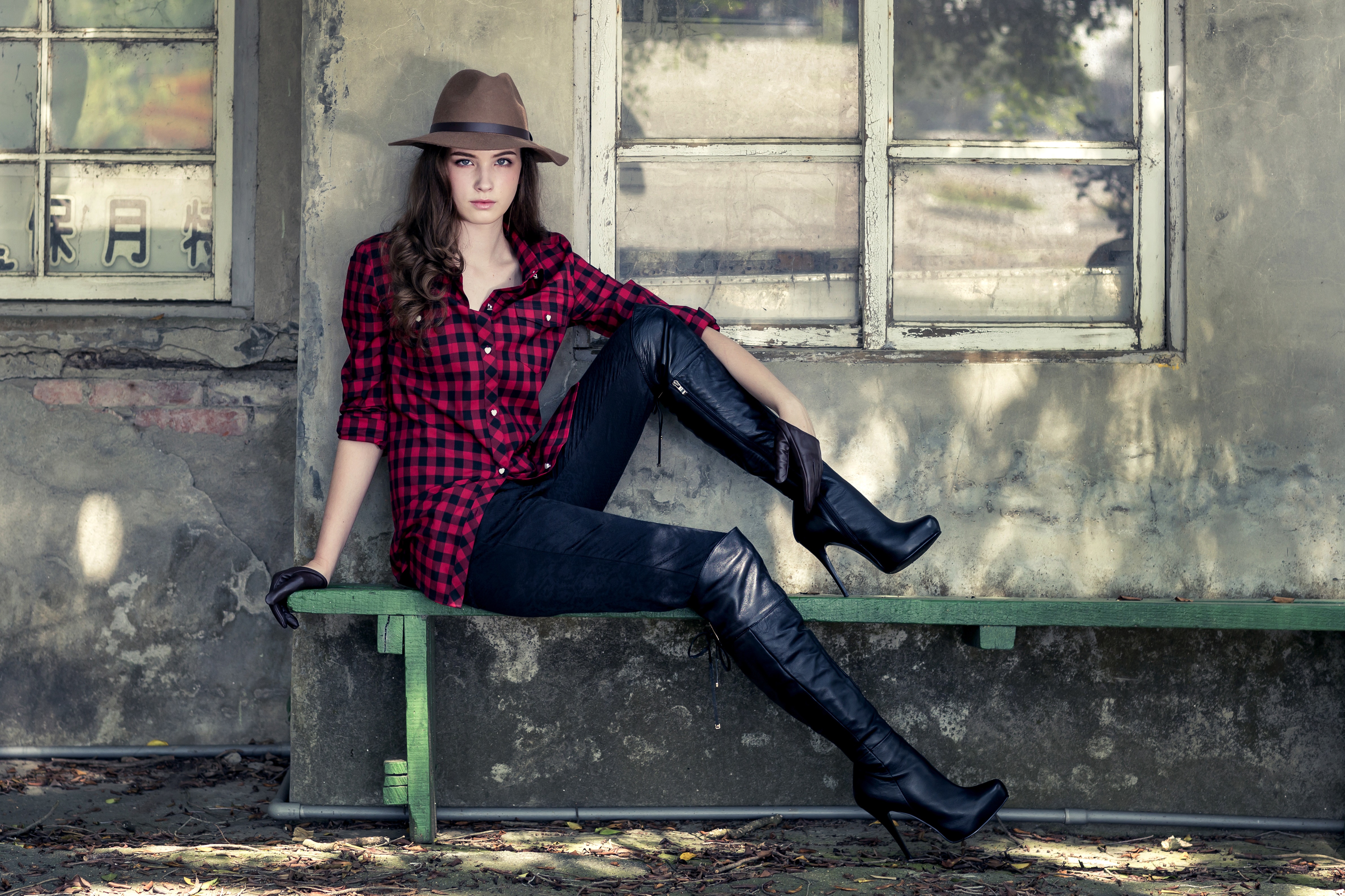 Woman in hat and boots sitting on bench HD Wallpaper