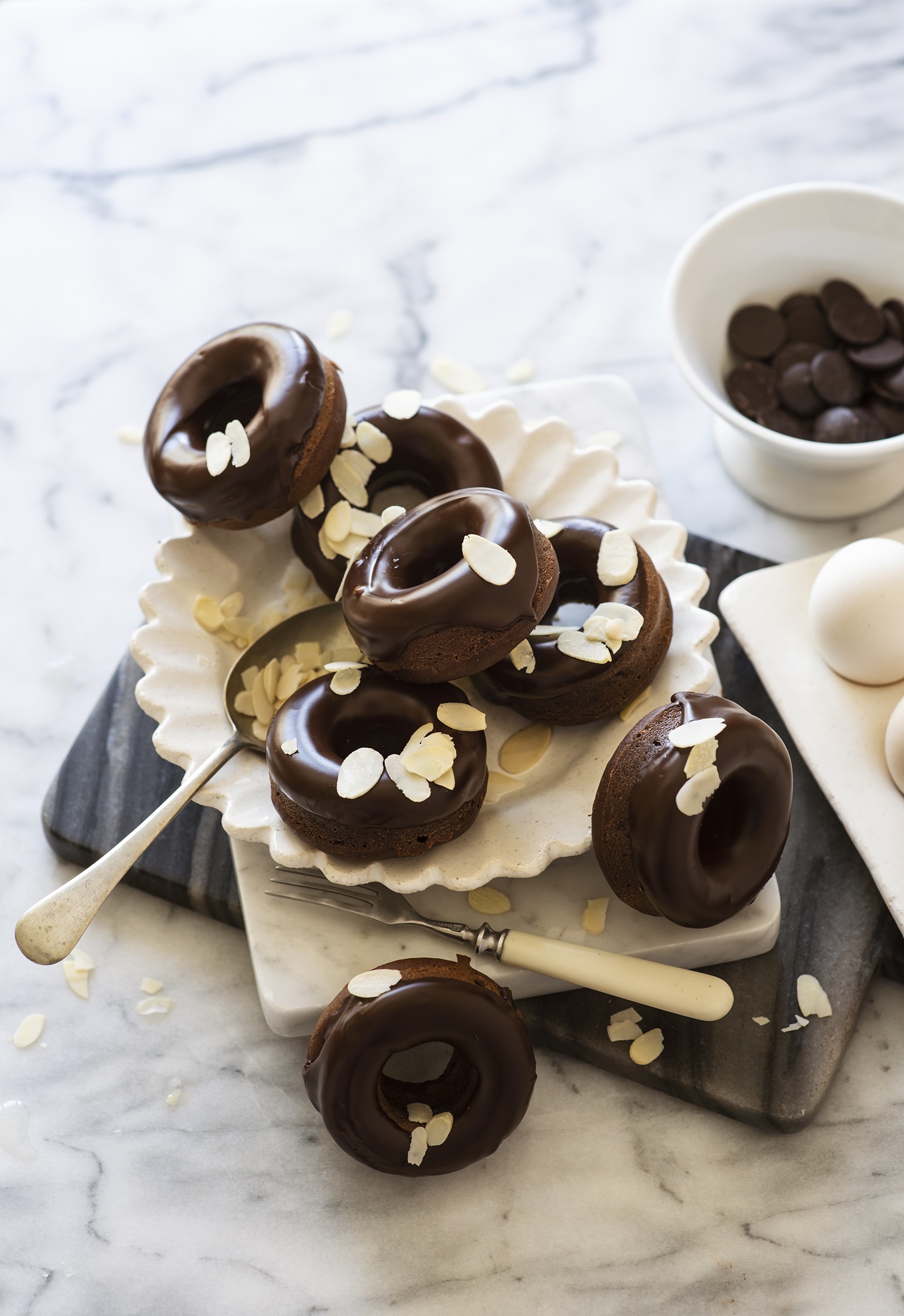Chocolate donuts with almond slivers on a marble surface HD Phone Wallpaper