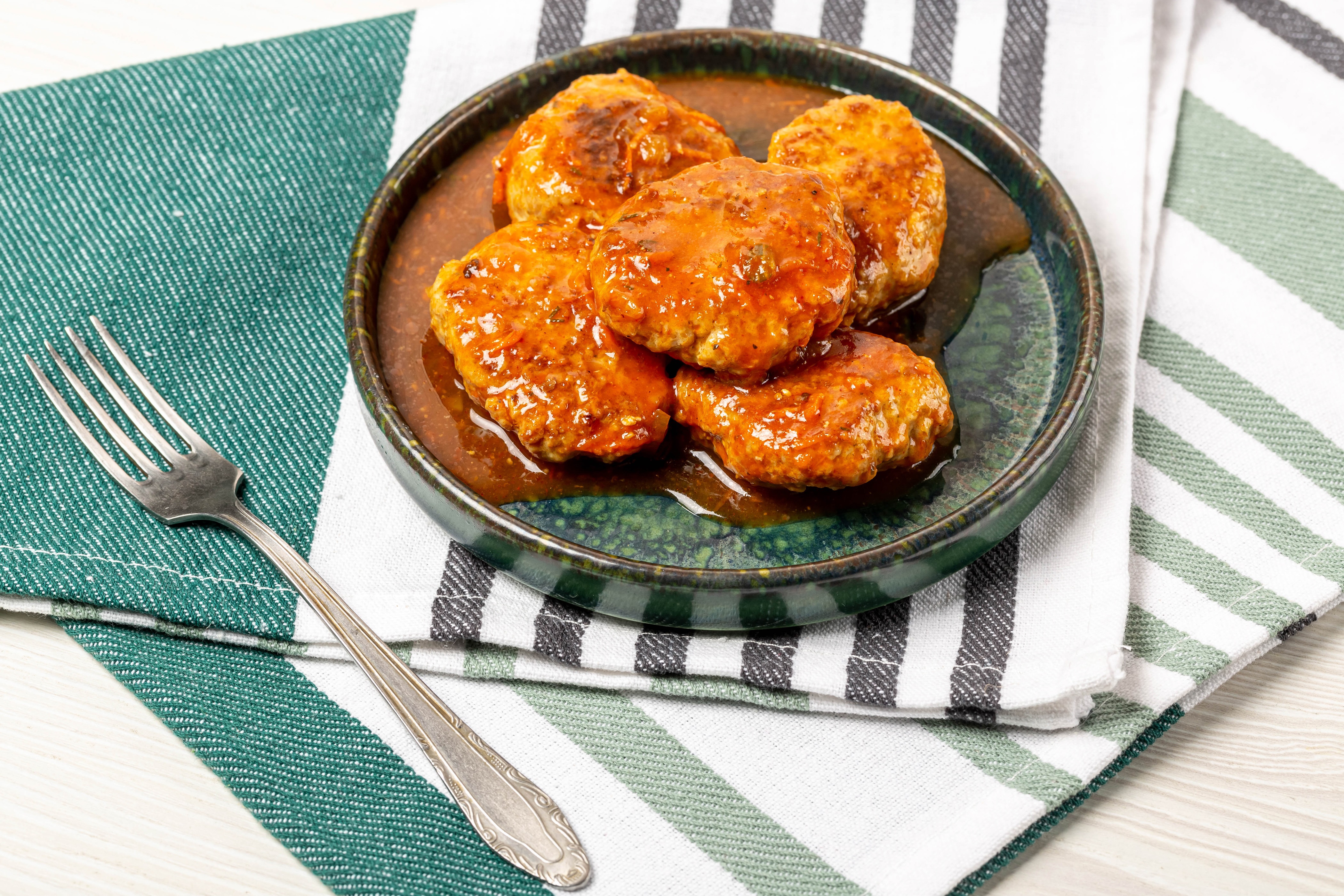 Frikadeller in sauce with a fork HD Wallpaper