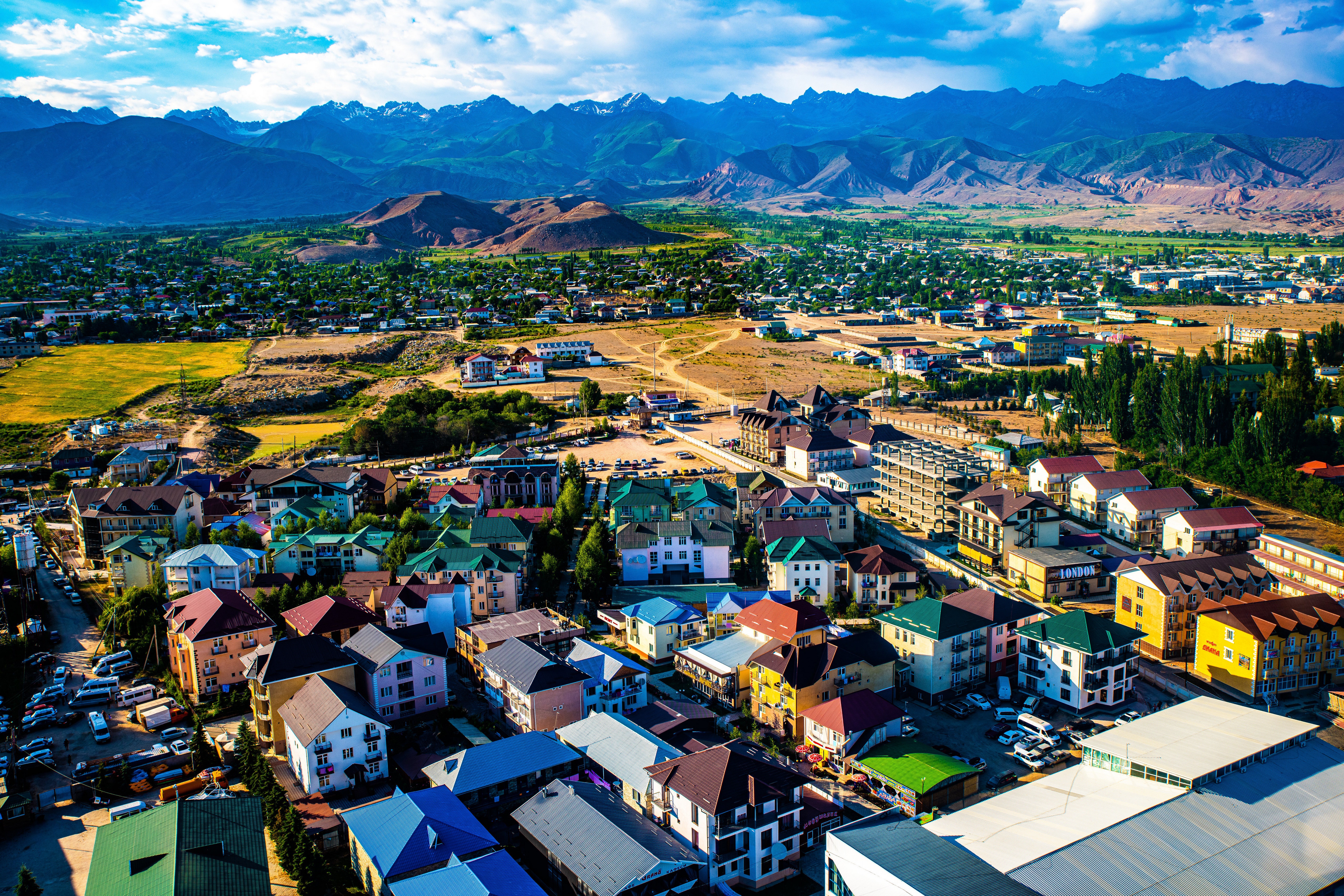 Bosteri, Kyrgyzstan: Houses and Mountains Under Clouds HD Wallpaper