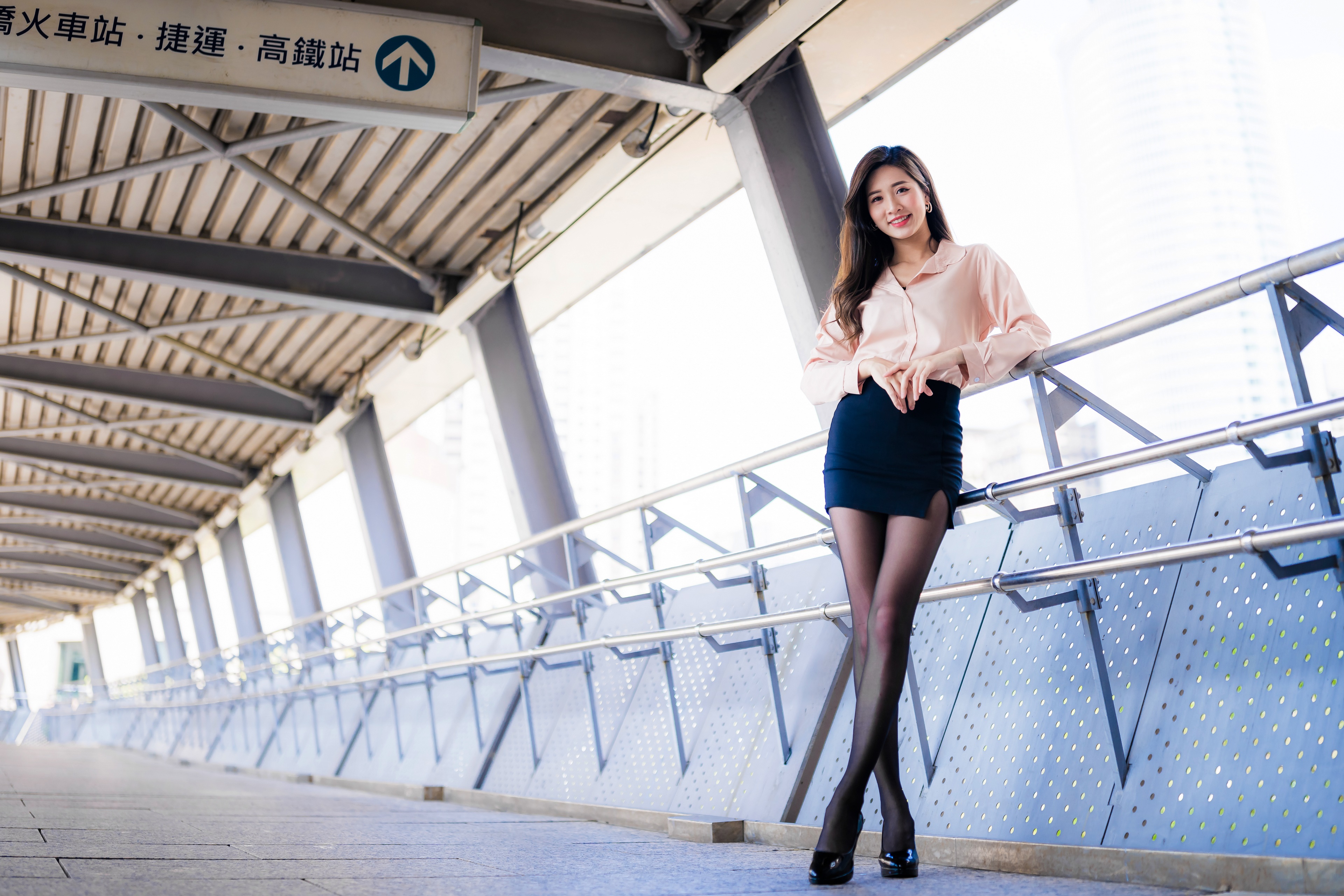 Asian woman in skirt and blouse posing on walkway HD Wallpaper
