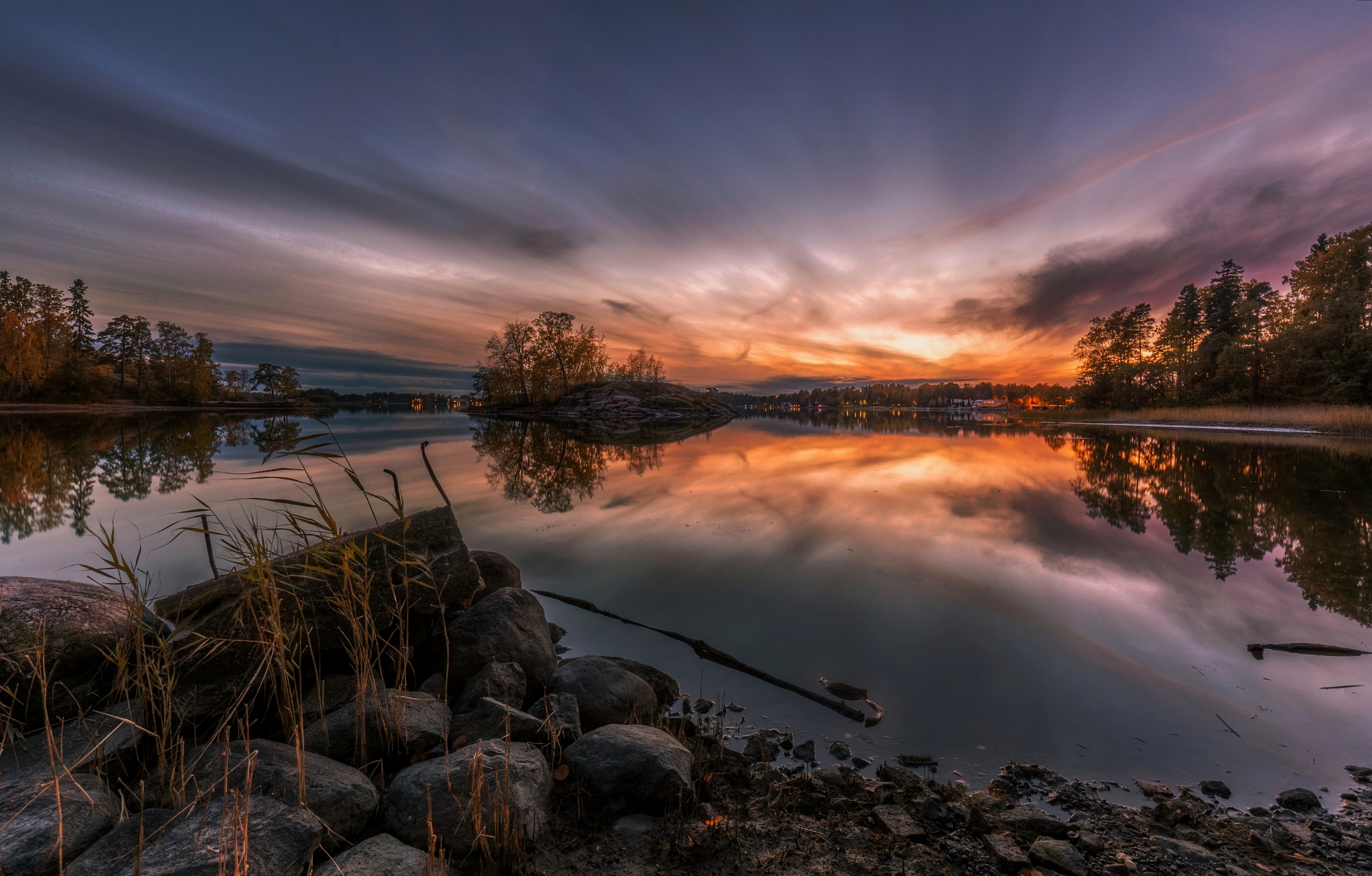 Sunset over a calm river with trees and rocks HD Wallpaper