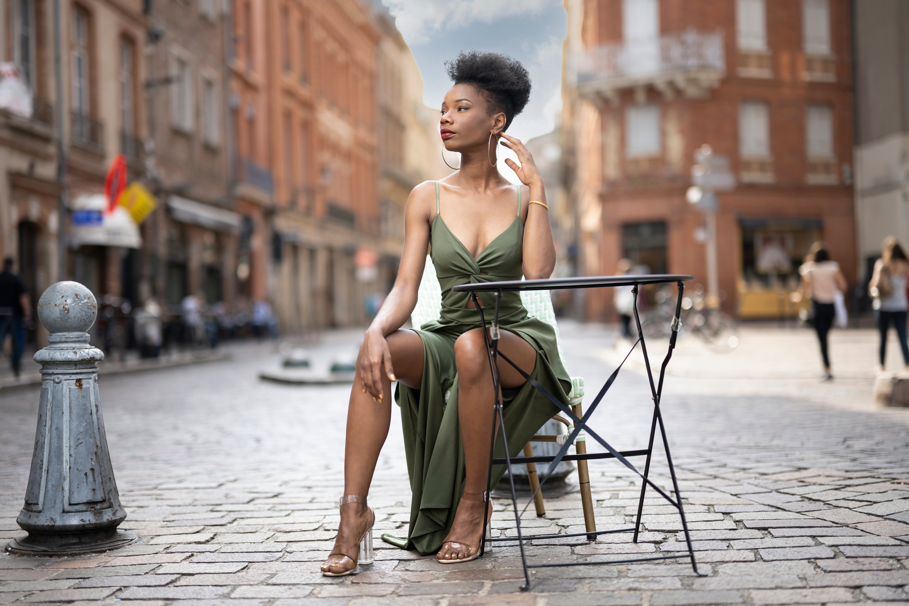 Woman in green dress sitting at a table HD Wallpaper