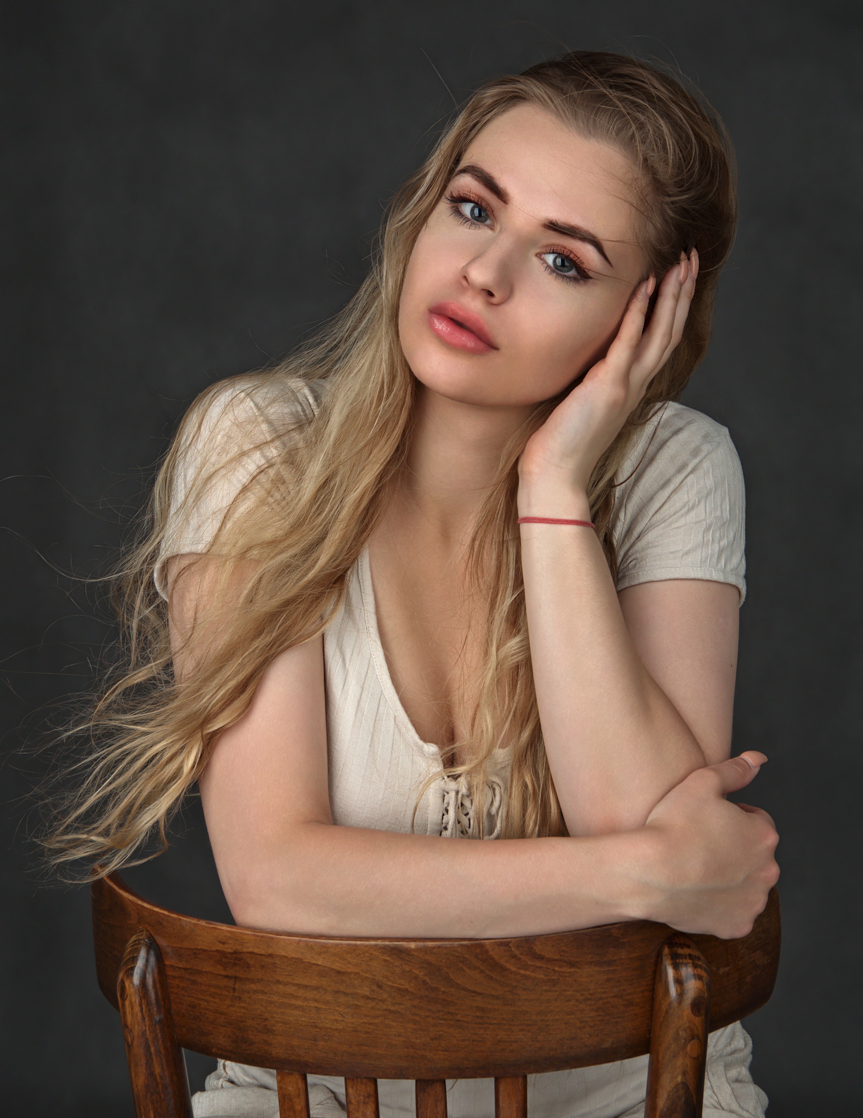 Blonde woman sitting on a wooden chair HD Phone Wallpaper