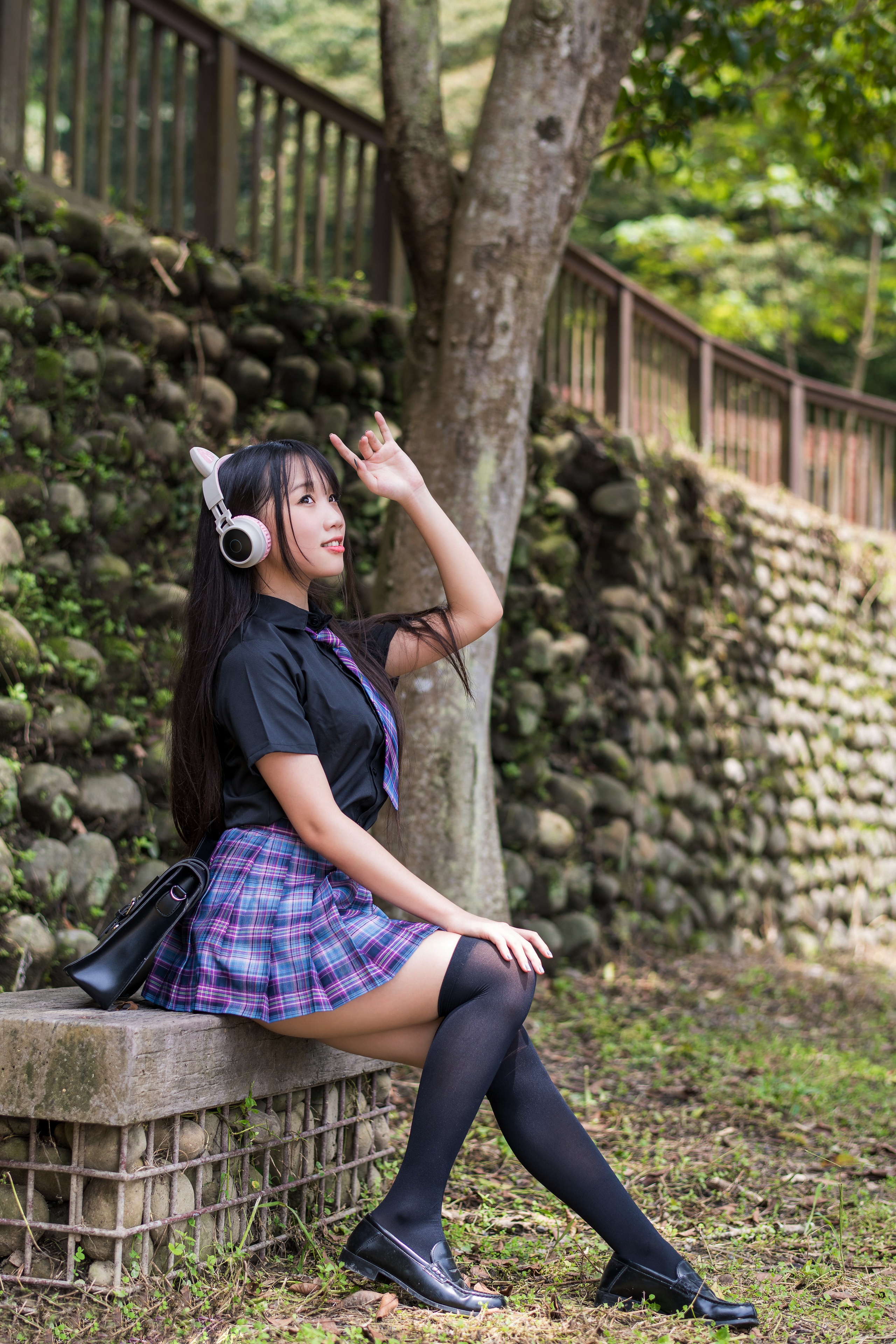 Asian schoolgirl with headphones sitting outdoors HD Phone Wallpaper