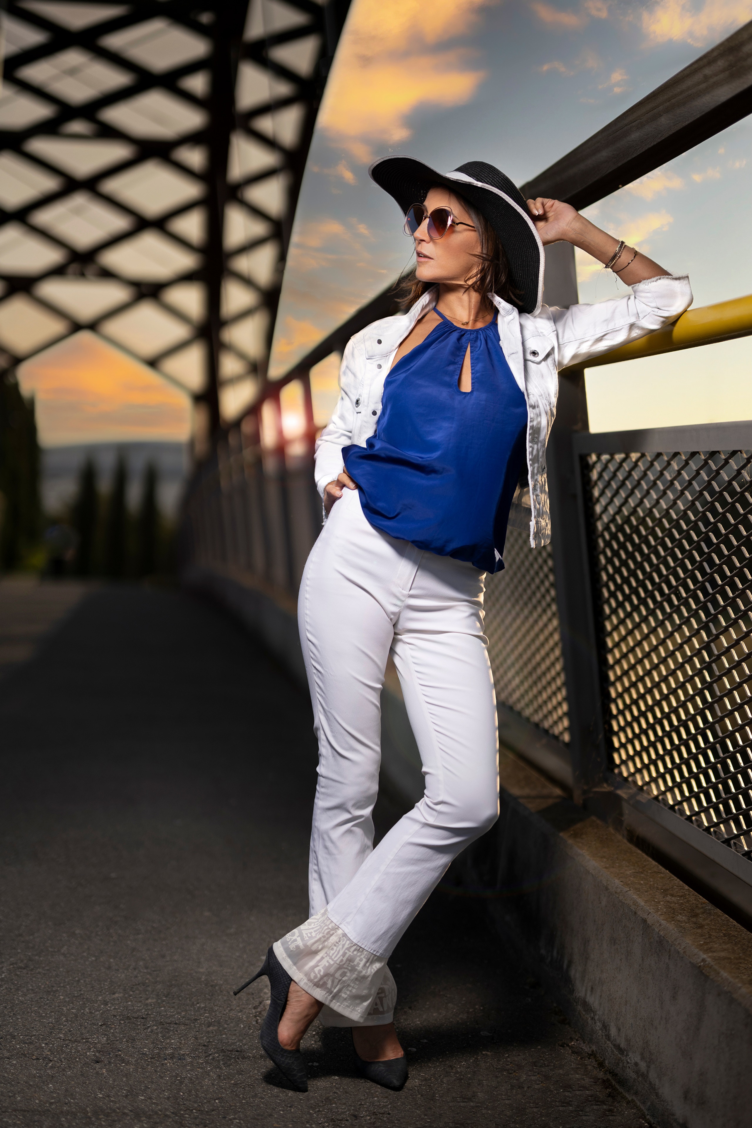 Woman in white trousers and blue blouse wearing a hat and glasses HD Phone Wallpaper